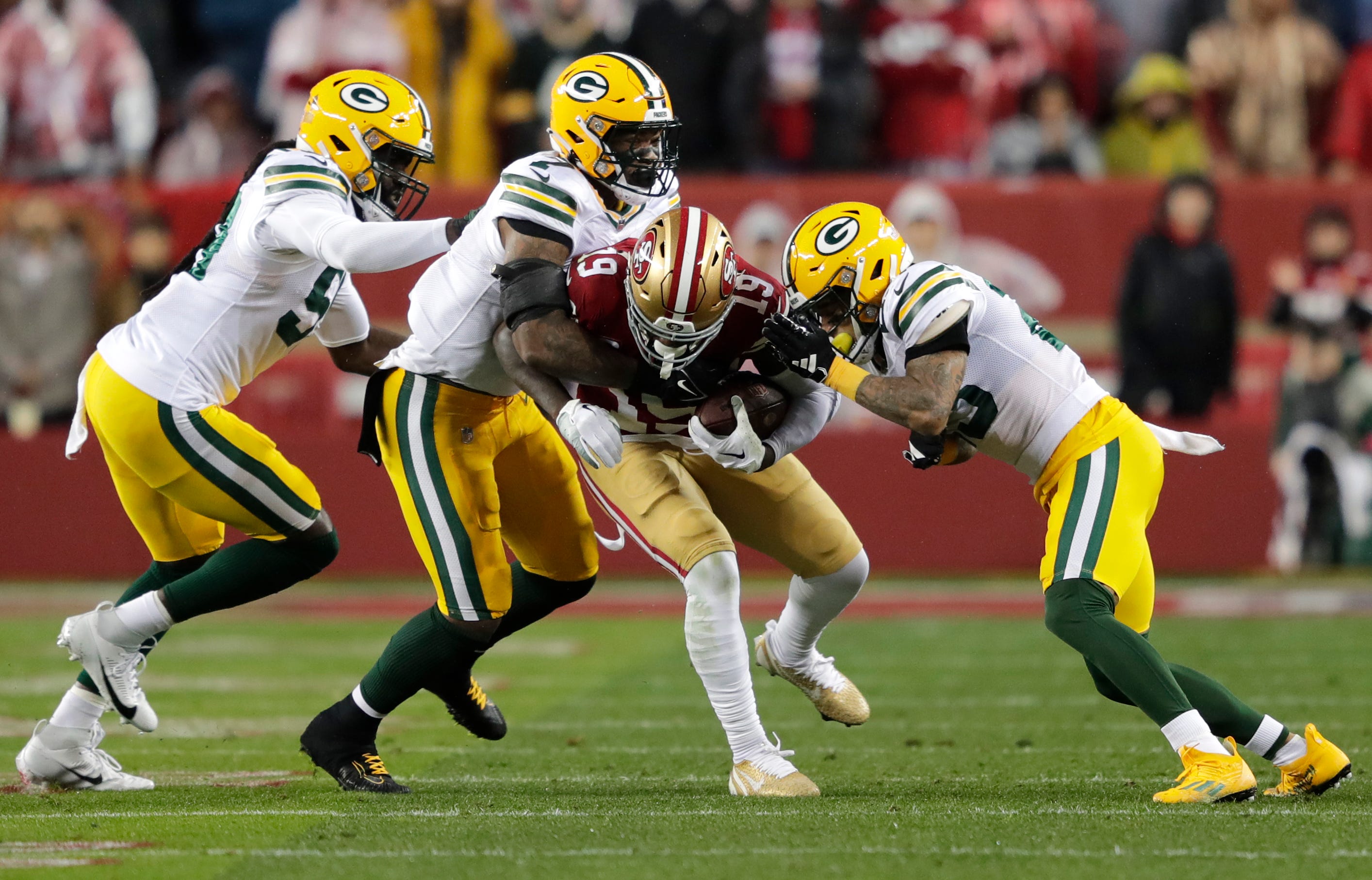 San Francisco 49ers wide receiver Deebo Samuel (19) gains yardage on a reception against Green Bay Packers linebacker De'Vondre Campbell (59), linebacker Quay Walker (7) and cornerback Jaire Alexander (23) during their NFC divisional playoff football game Saturday, January 20, 2024, at Levi's Stadium in Santa Clara, California.