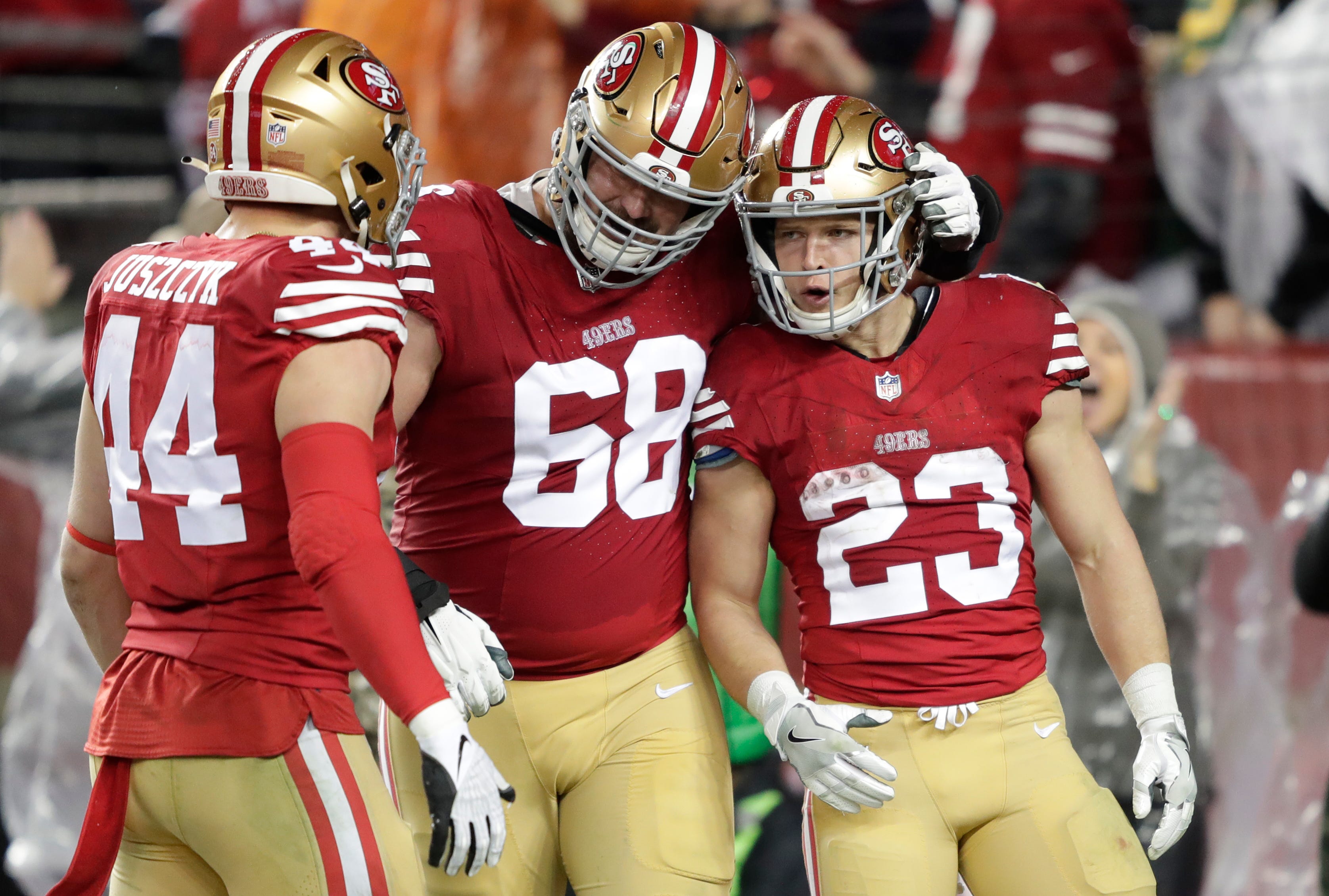 San Francisco 49ers running back Christian McCaffrey (23) celebrates scoring a touchdown in the third quarter with fullback Kyle Juszczyk (44) and offensive tackle Colton McKivitz (68) against the Green Bay Packers during their NFC divisional playoff football game Saturday, January 20, 2024, at Levi's Stadium in Santa Clara, California.
