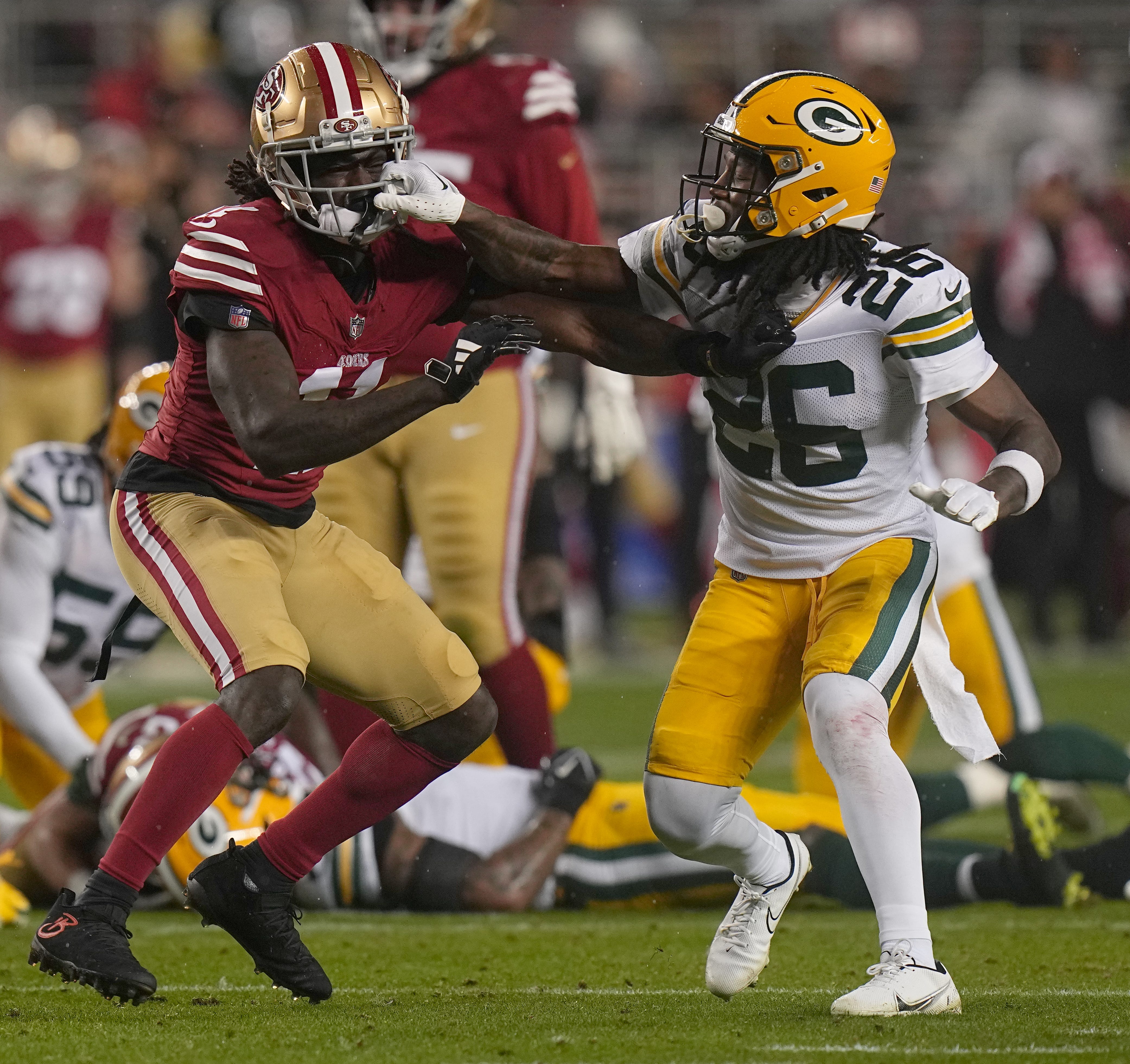 San Francisco 49ers wide receiver Brandon Aiyuk (11) and Green Bay Packers safety Darnell Savage (26) mix it up during the first quarter of their NFC divisional playoff game Saturday, January 20, 2024 at Levi’ Stadium in Santa Clara, California.