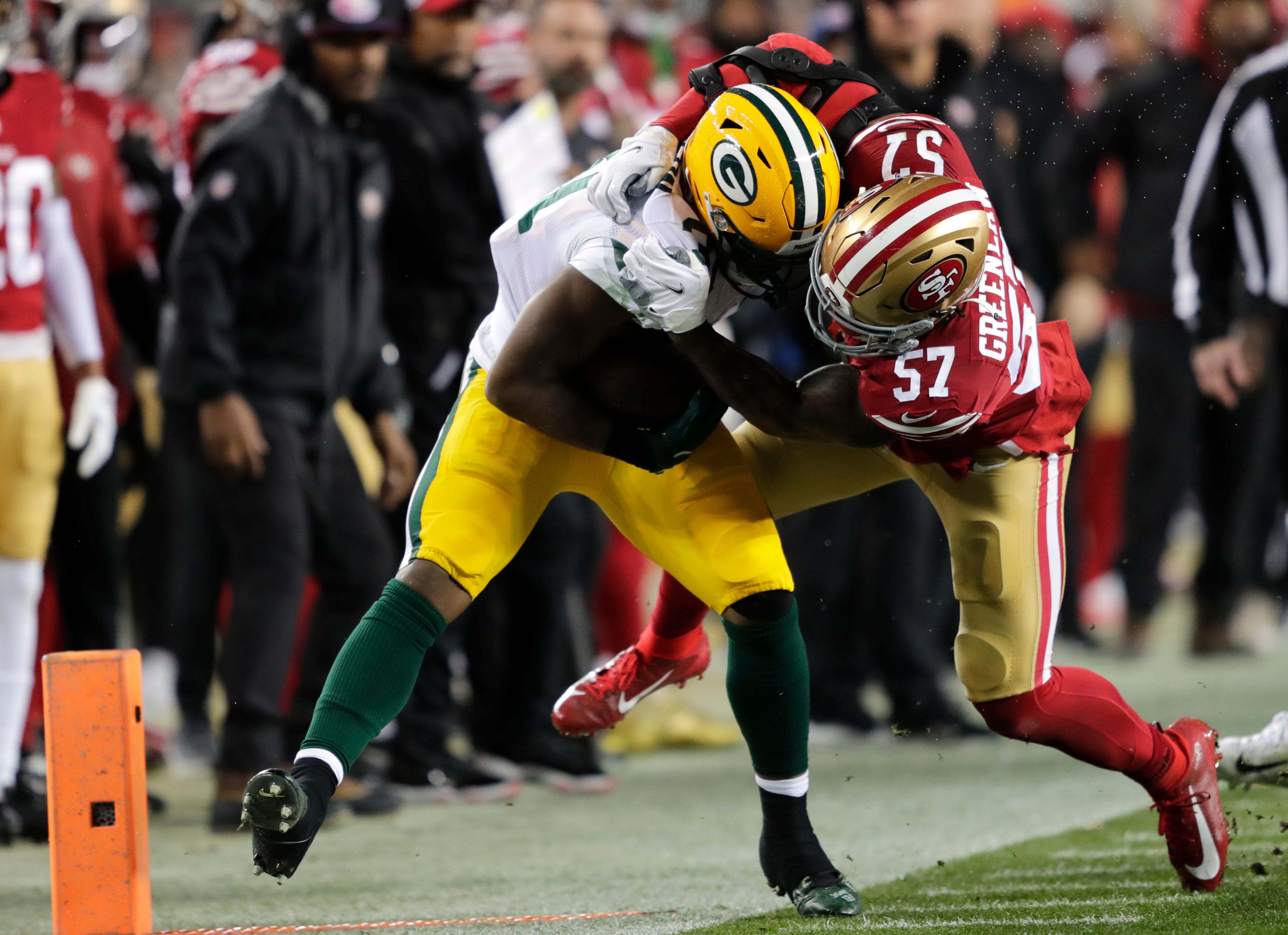 Green Bay Packers running back Emanuel Wilson (31) is knocked out of bounds by San Francisco 49ers linebacker Dre Greenlaw (57) during their NFC divisional playoff football game Saturday, January 20, 2024, at Levi's Stadium in Santa Clara, California.