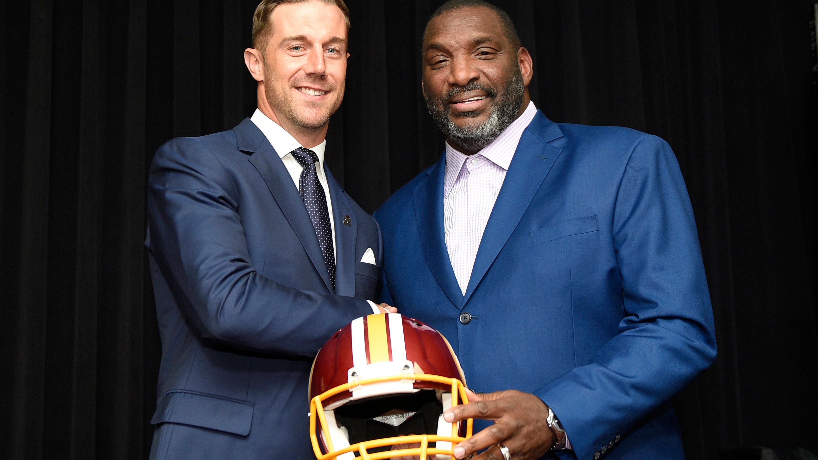 Newly signed Washington Redskins quarterback Alex Smith, left, poses with Doug Williams, the NFL football team's senior vice president of player personnel, during a news conference Thursday, March 15, 2018, in Ashburn, Va. (AP Photo/Nick Wass)