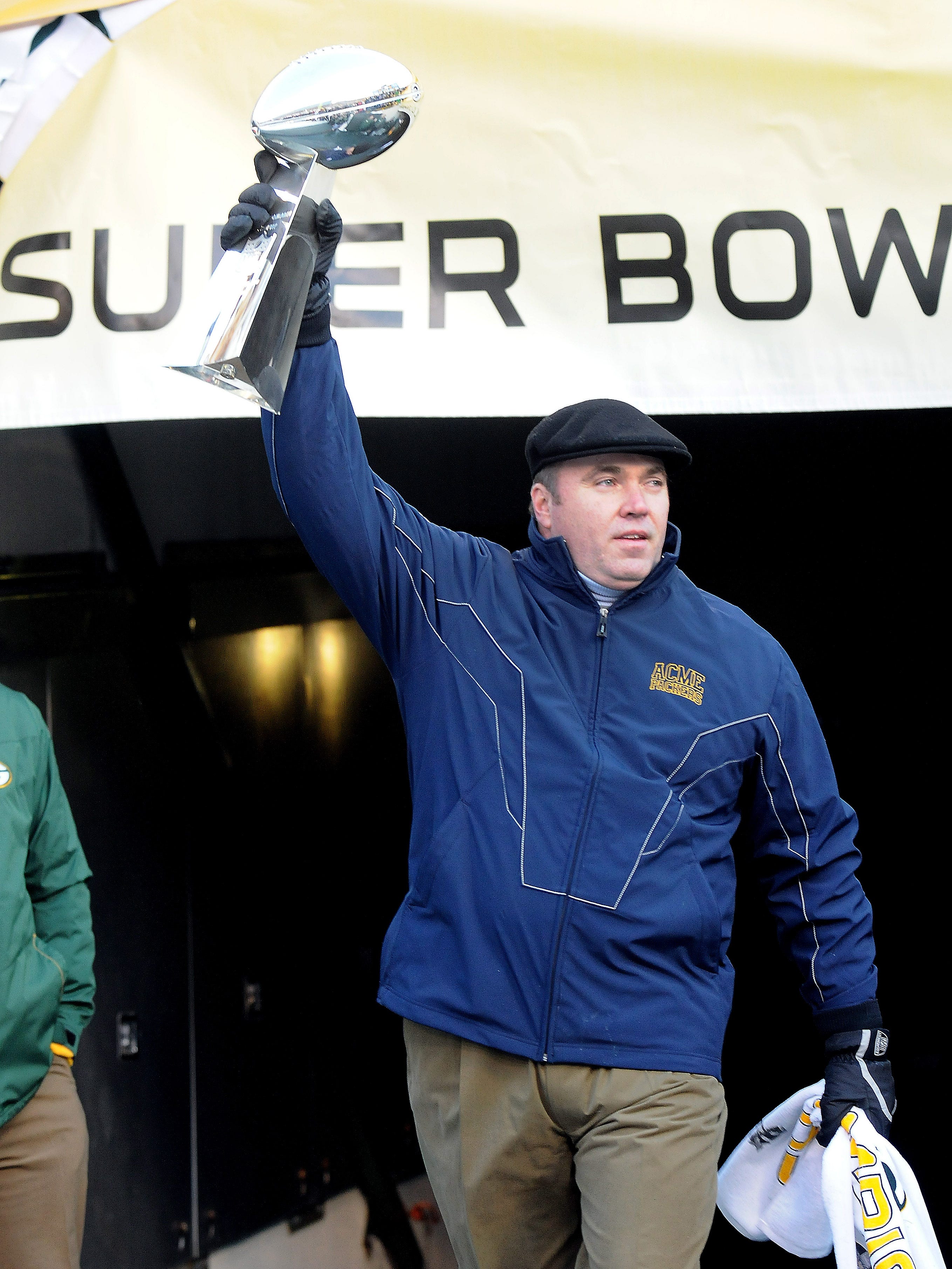 Mike McCarthy enters Lambeau Field carrying the Lombardi Trophy during the 'Return to Titletown' celebration for the Super Bowl XLV champion Green Bay Packers is held on Feb. 8, 2011, at Lambeau Field.