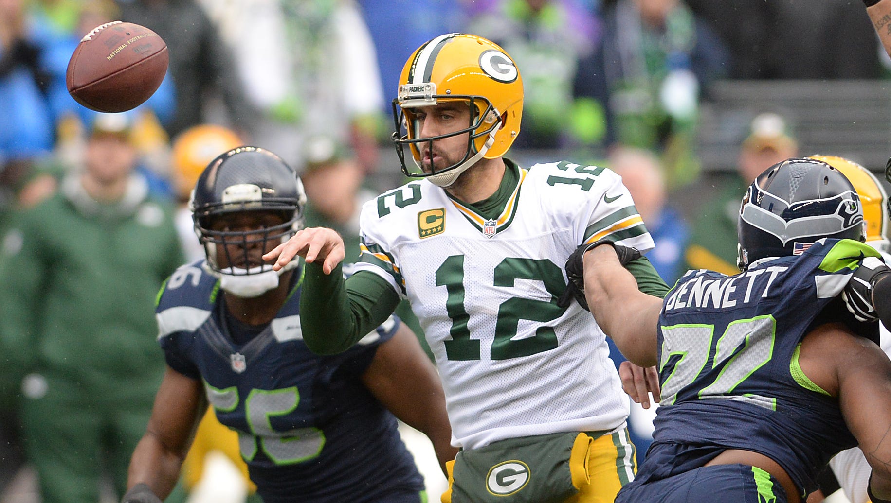 Green Bay Packers quarterback Aaron Rodgers flips a short pass that would fall incomplete under heay pressure against the Seattle Seahawks at CenturyLink FIeld in Seattle January 18, 2015.