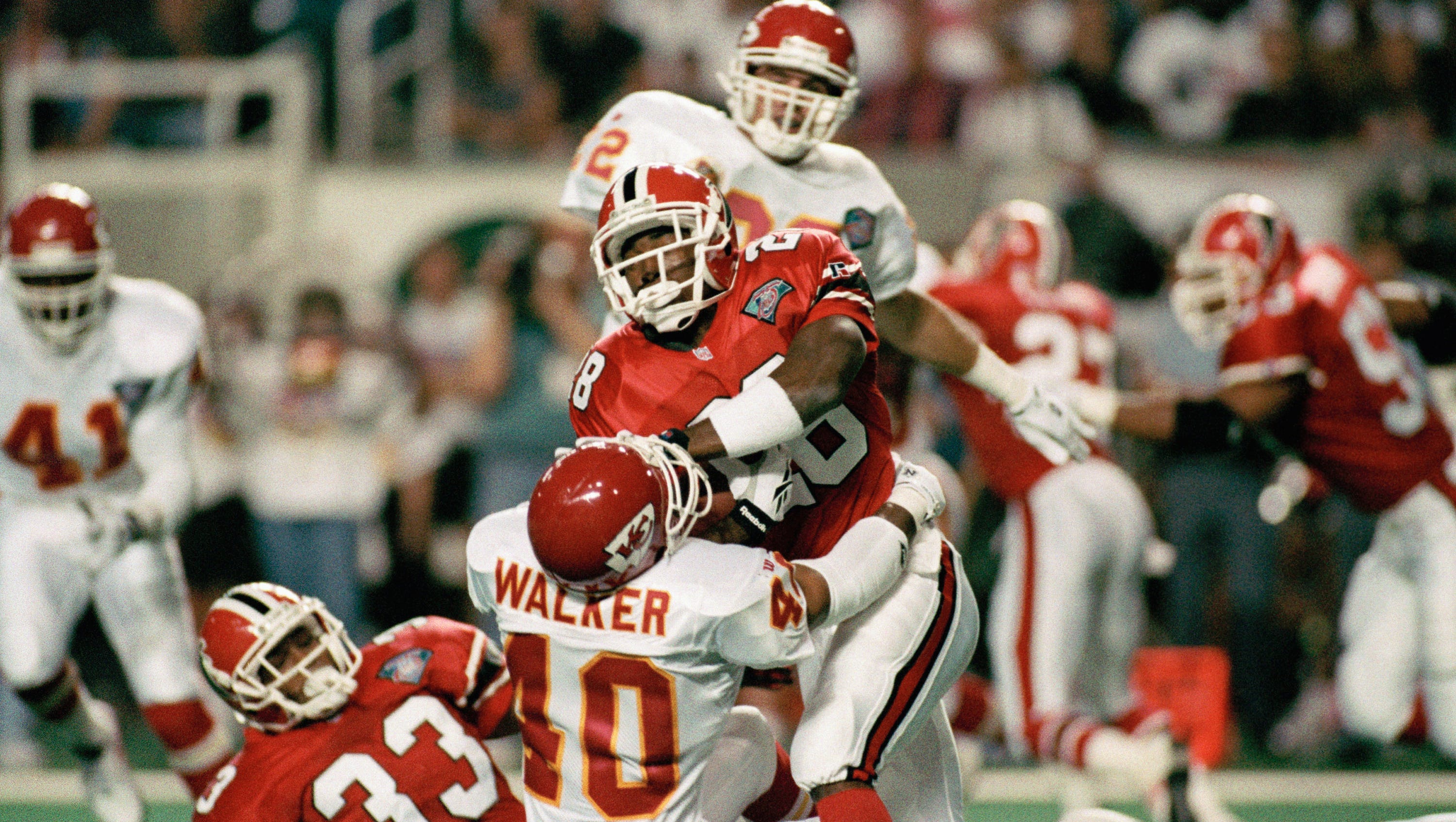 Atlanta Falcons running back Tony Smith (28) stiff arms Kansas City Chiefs safety Bracey Walker (40) as he fights for yardage on Sept. 18, 1994 in Atlanta
