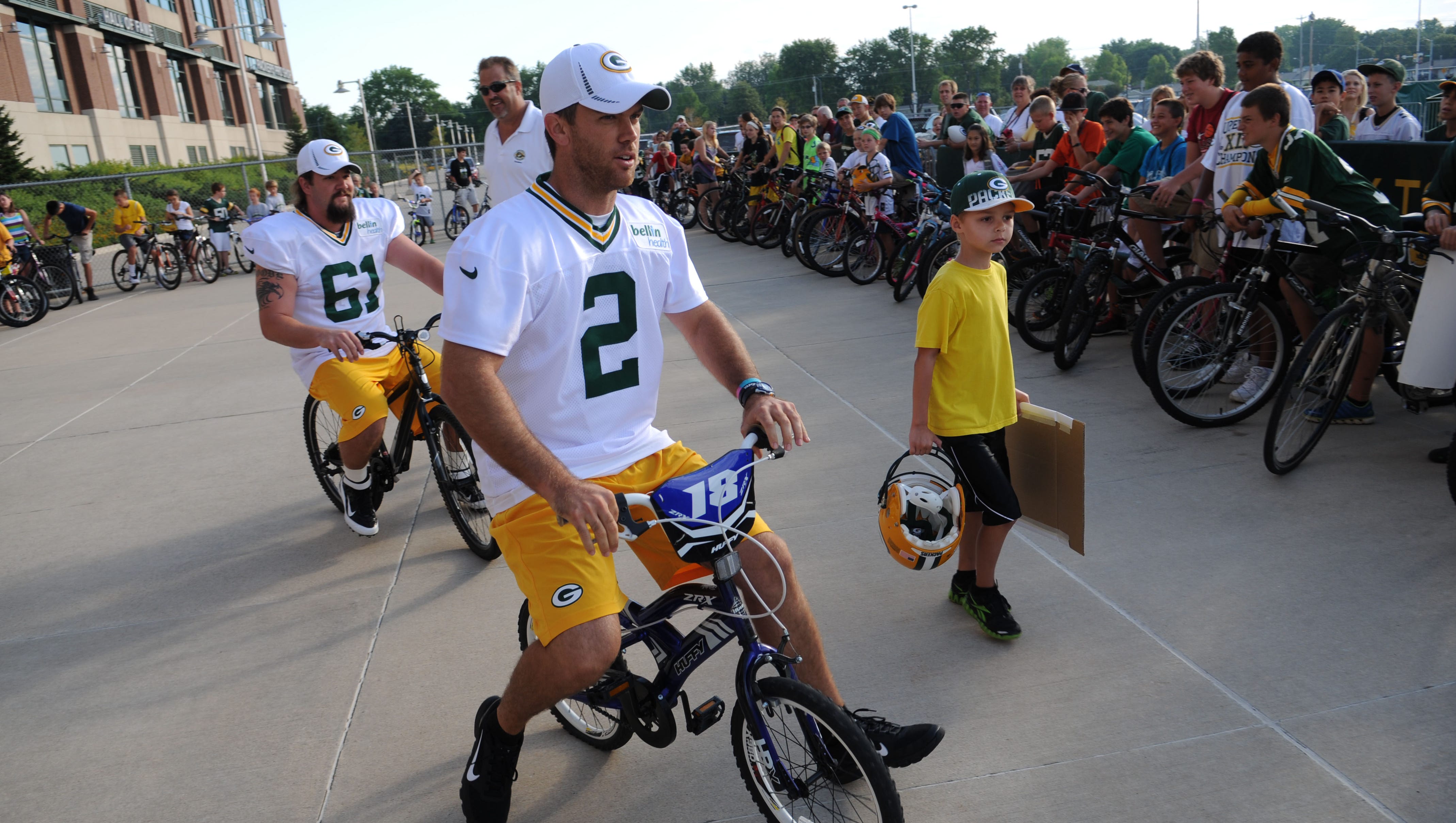 Mason Crosby rides Mason Chaltry's bike to the first day of Packers training camp on July 25, 2012, at Ray Nitschke Field.