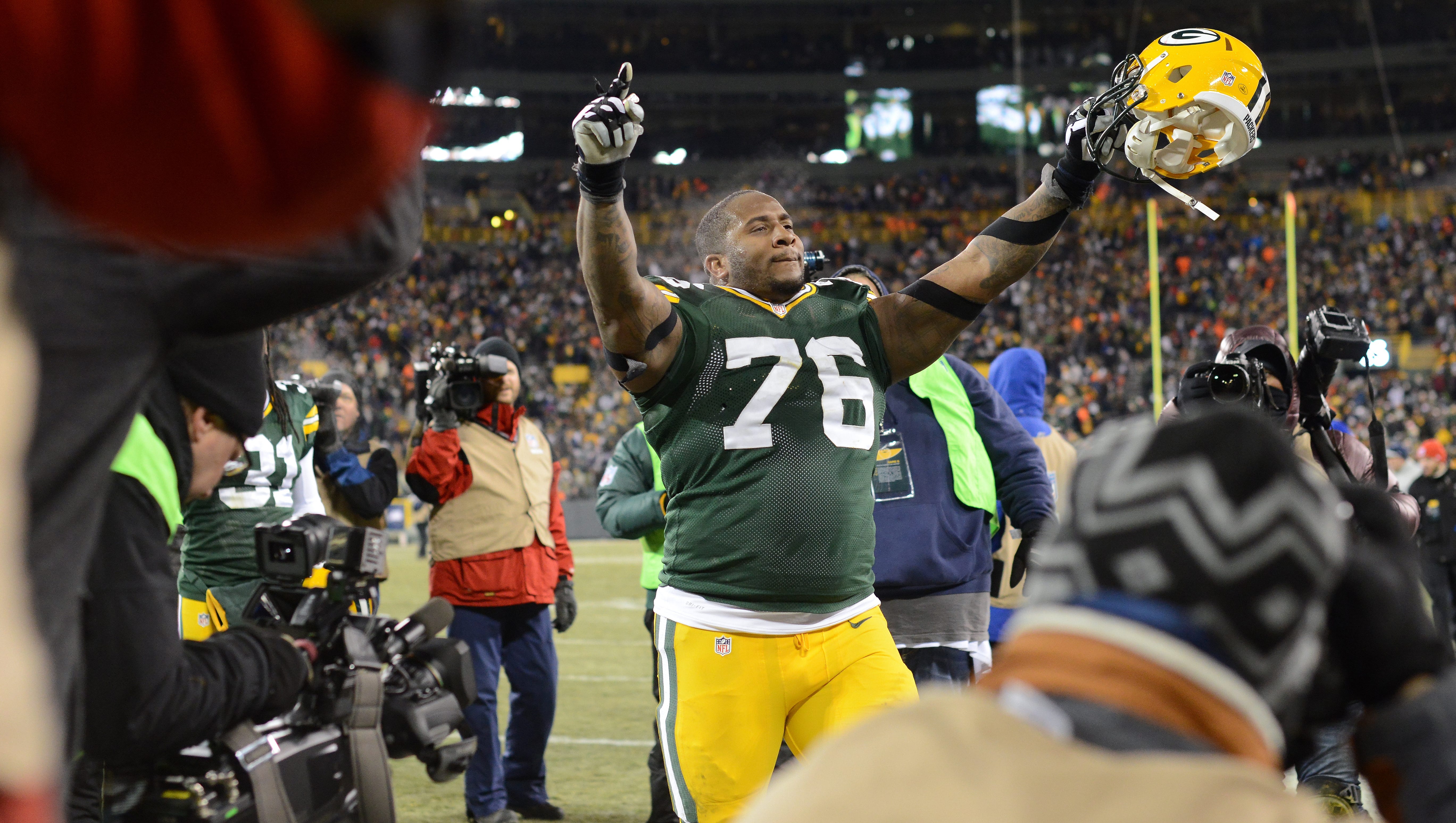 Green Bay Packers defensive tackle Mike Daniels (76) raises his hands to the crowd as he makes his way to the locker room following a victory over the New England Patriots on Nov. 30, 2014, at Lambeau Field.