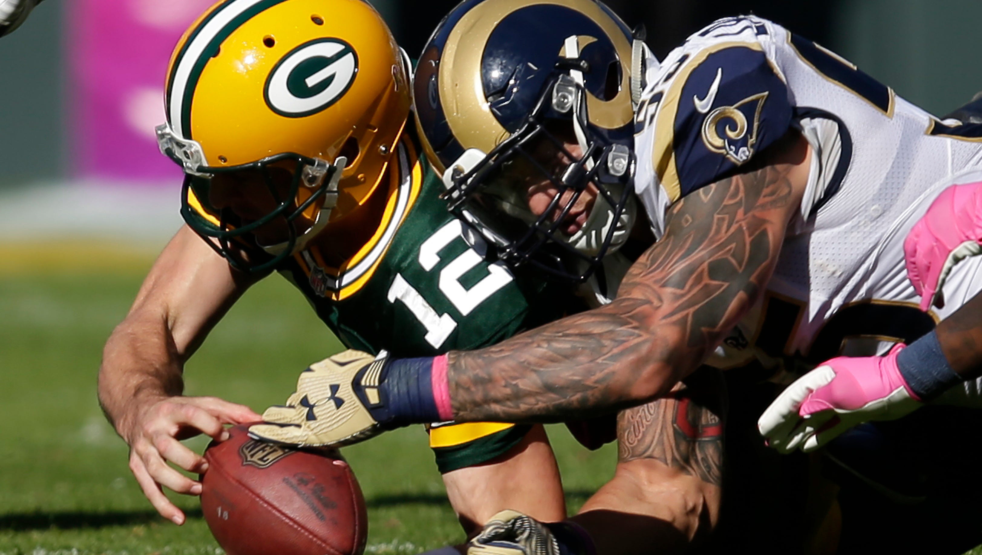 Green Bay Packers quarterback Aaron Rodgers fumbles the ball against the St. Louis Rams.