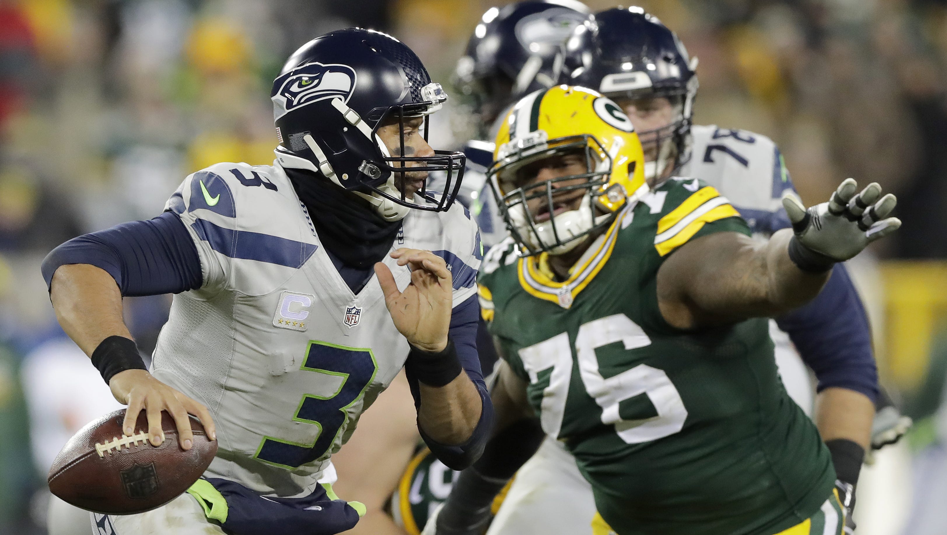 Seattle Seahawks quarterback Russell Wilson (3) scrambles away from Green Bay Packers defensive end Mike Daniels (76) in the fourth quarter on Dec. 11, 2016, at Lambeau Field in Green Bay.