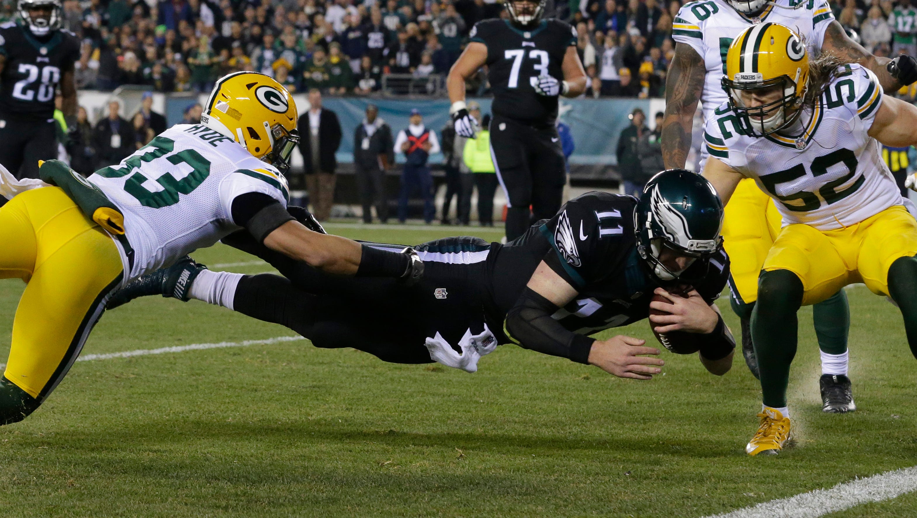 Philadelphia Eagles quarterback Carson Wentz (11) dives past Green Bay Packers strong safety Micah Hyde (33) and outside linebacker Clay Matthews (52) to scores a touchdown during the first quarter of their game Monday, November 28, 2016 at Lincoln Financial Field in Philadelphia, Penn.