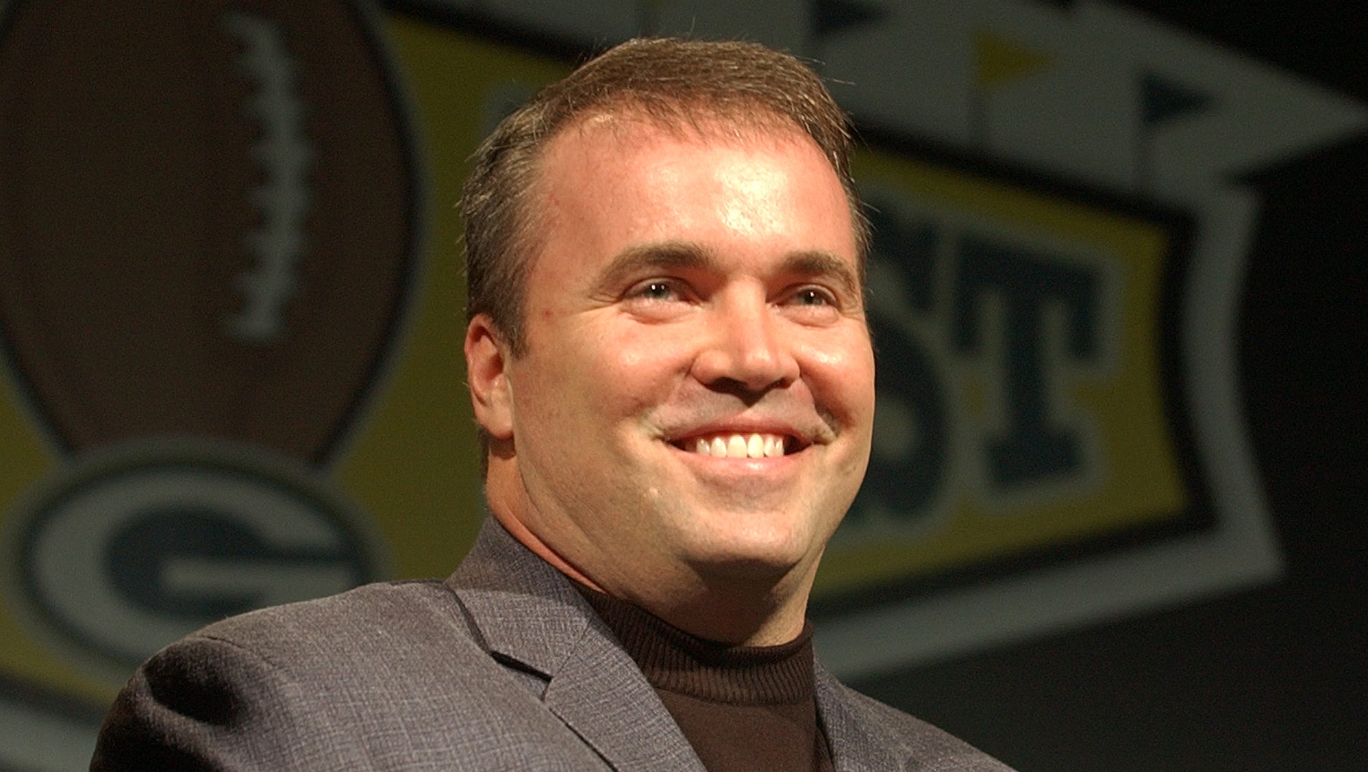 Packers coach Mike McCarthy smiles at the crowd during Fan Fest in the Lambeau Field Atrium.