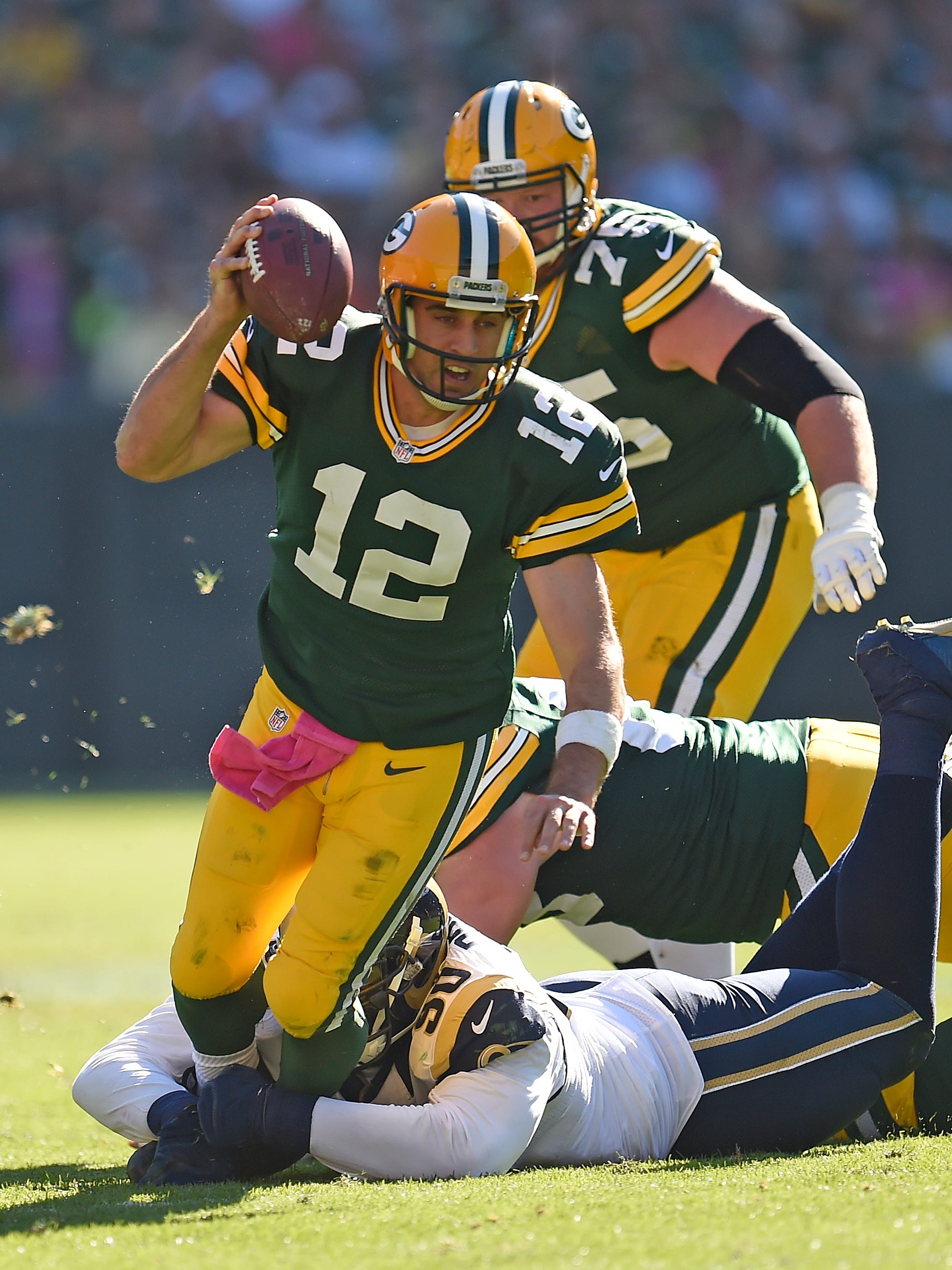 Green Bay Packers quarterback Aaron Rodgers (12) gets tackled from behind by St. Louis Rams defensive tackle Michael Brockers (90) at Lambeau Field October 11, 2015.