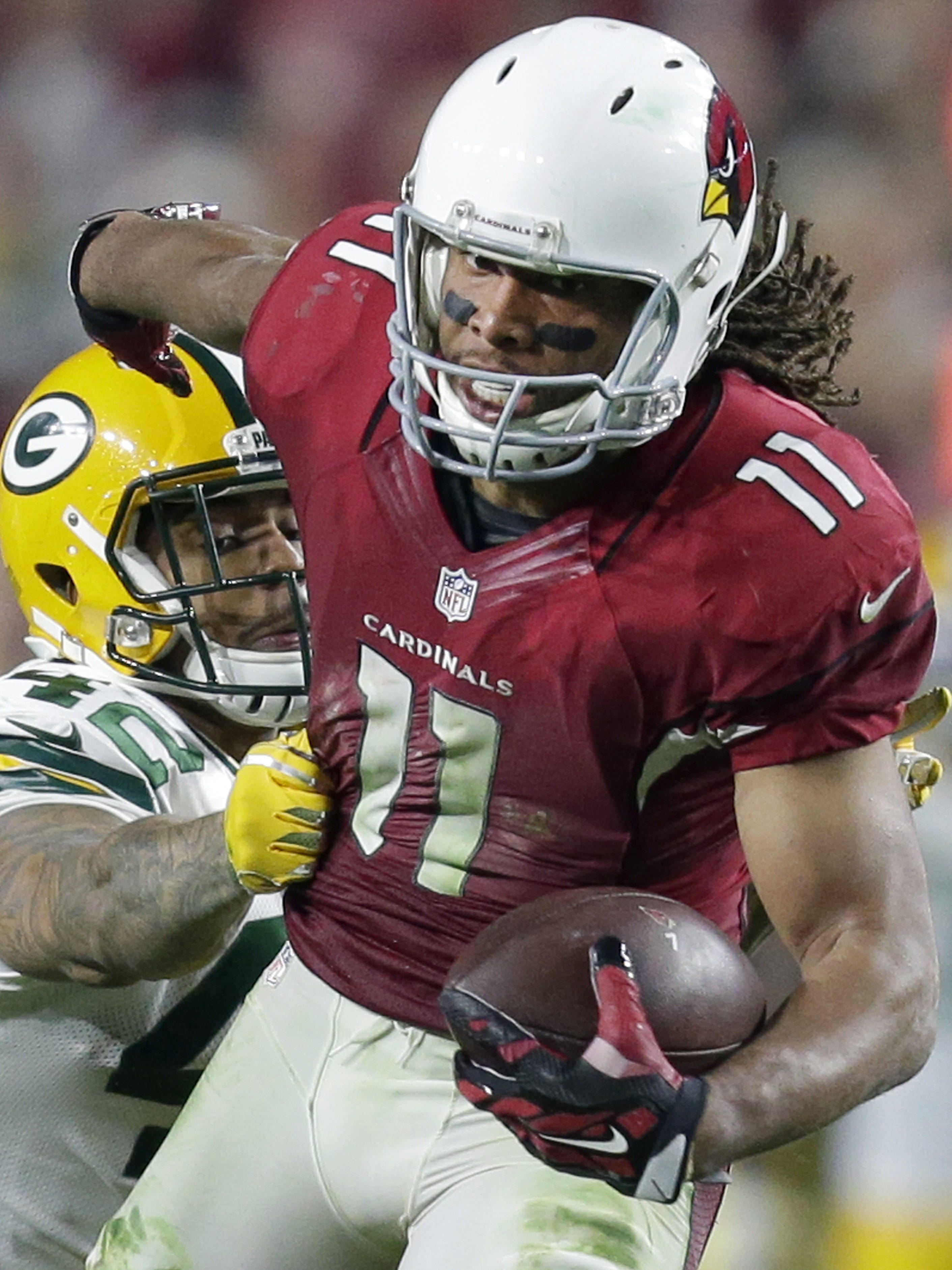 Arizona receiver Larry Fitzgerald breaks away for a 75-yard pass play in overtime to set up the Cardinals for a winning touchdown in a 2015 playoff games against the Packers.