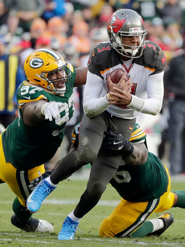 Green Bay Packers nose tackle Kenny Clark (97) and defensive end Mike Daniels (76) tackle Tampa Bay Buccaneers quarterback Jameis Winston (3) in the fourth quarter at Lambeau Field on Sunday, December 3, 2017 in Green Bay, Wis.
