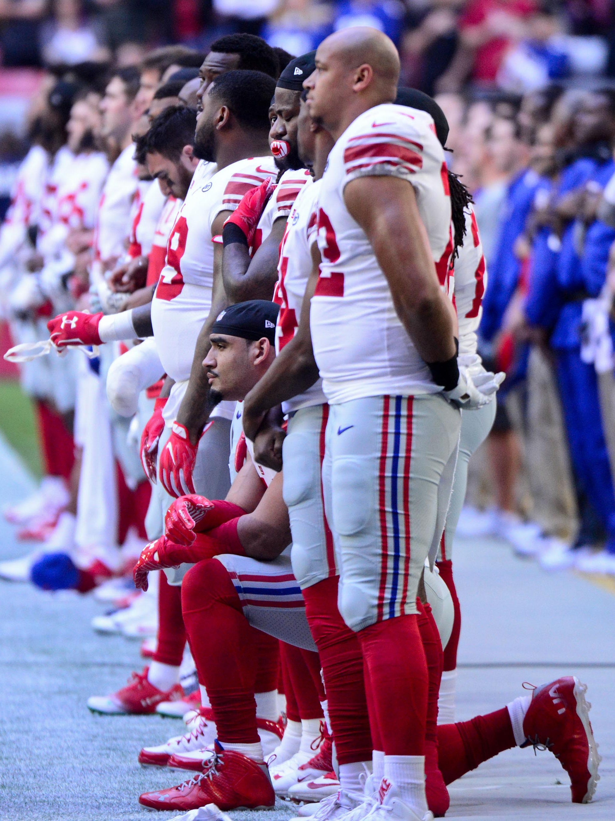 New York Giants defensive end Olivier Vernon (54) kneels during the National Anthem prior to the game against the Arizona Cardinals at University of Phoenix Stadium.