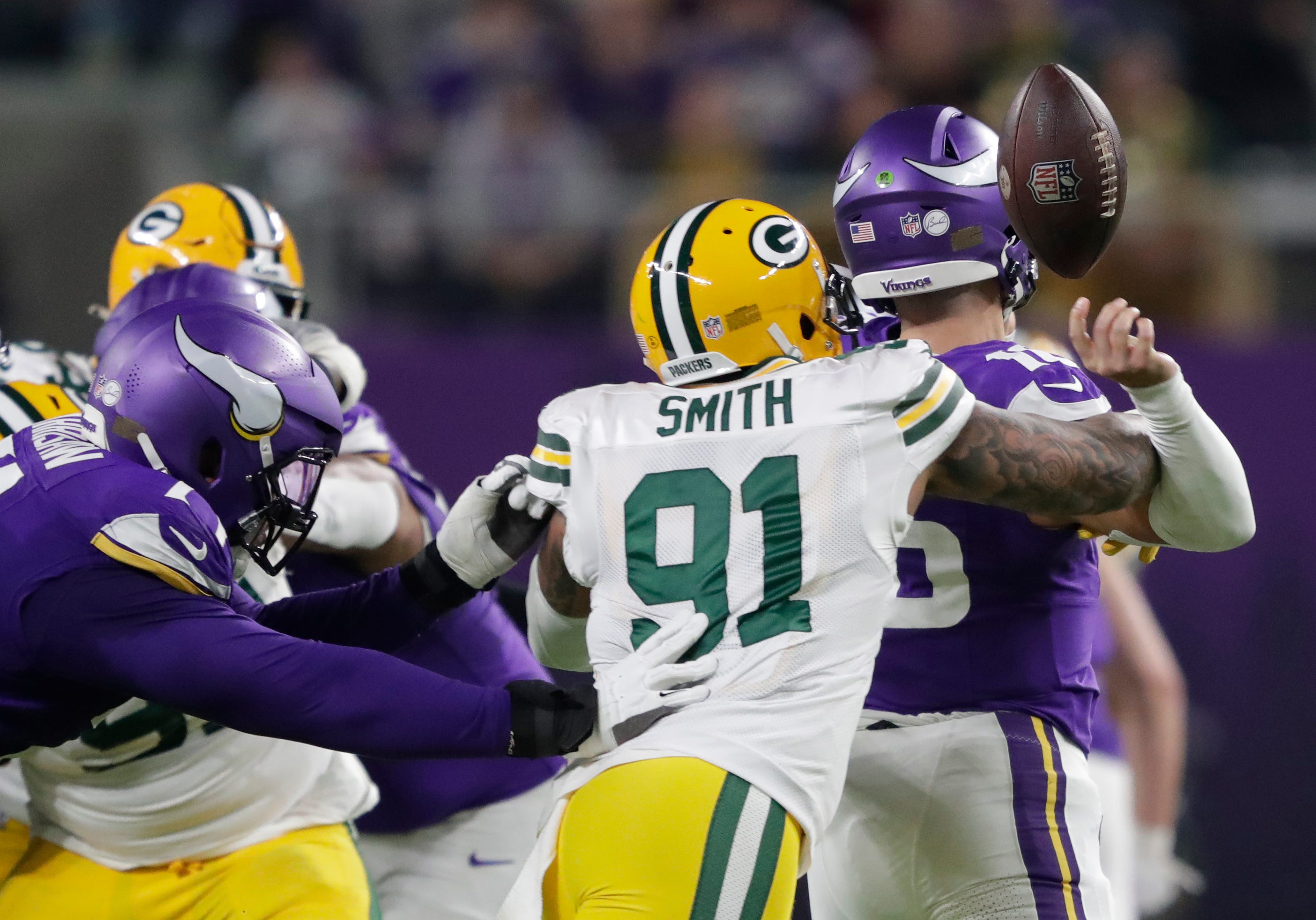 Green Bay Packers linebacker Preston Smith (91) forces a fumble by Minnesota Vikings quarterback Jaren Hall (16) during their football game Sunday, December 31, 2023, at U.S. Bank Stadium in Minneapolis, Minnesota.