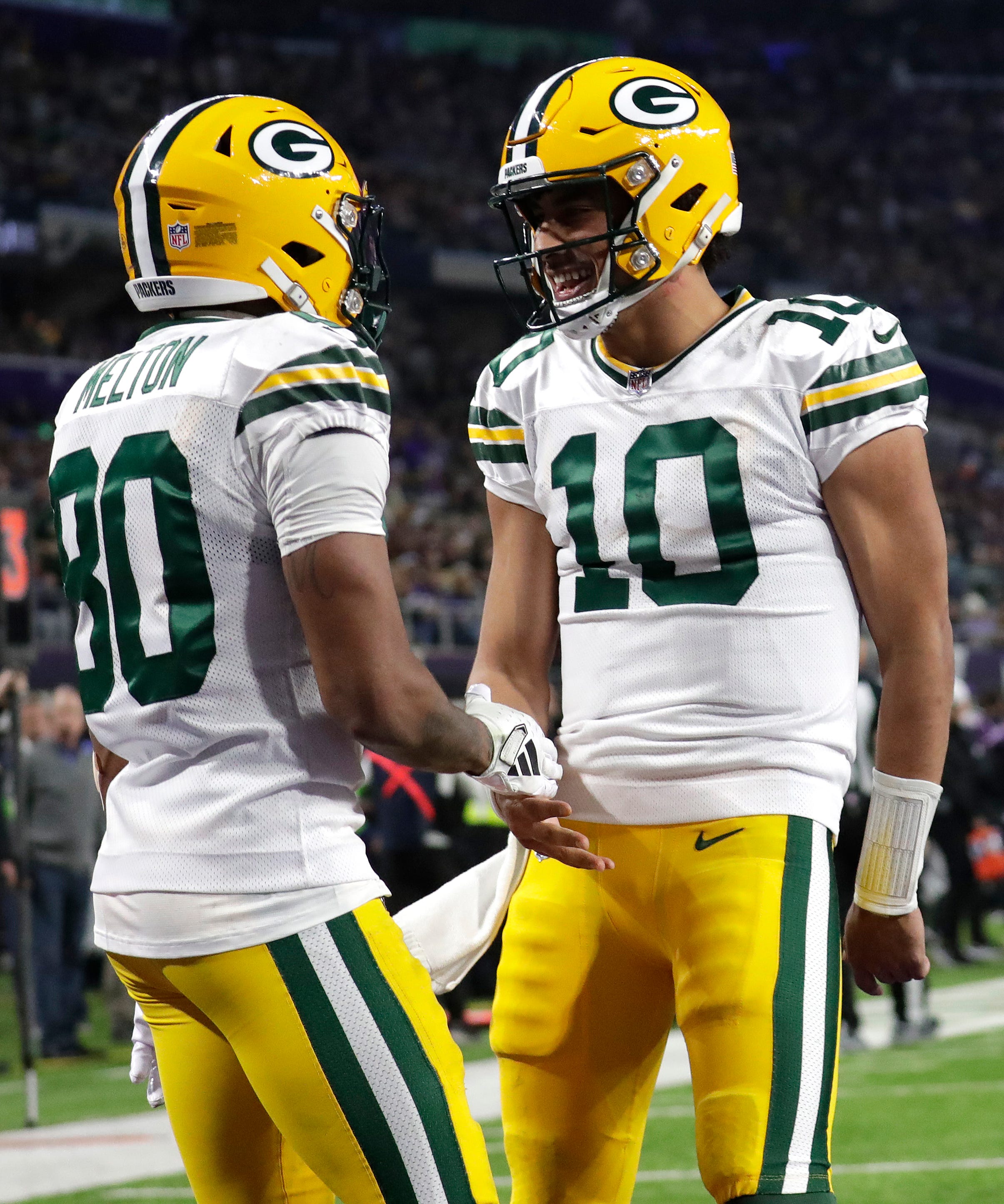 Green Bay Packers wide receiver Bo Melton (80) celebrates his touchdown reception with quarterback Jordan Love (10) against the Minnesota Vikings during their football game Sunday, December 31, 2023, at U.S. Bank Stadium in Minneapolis, Minnesota.