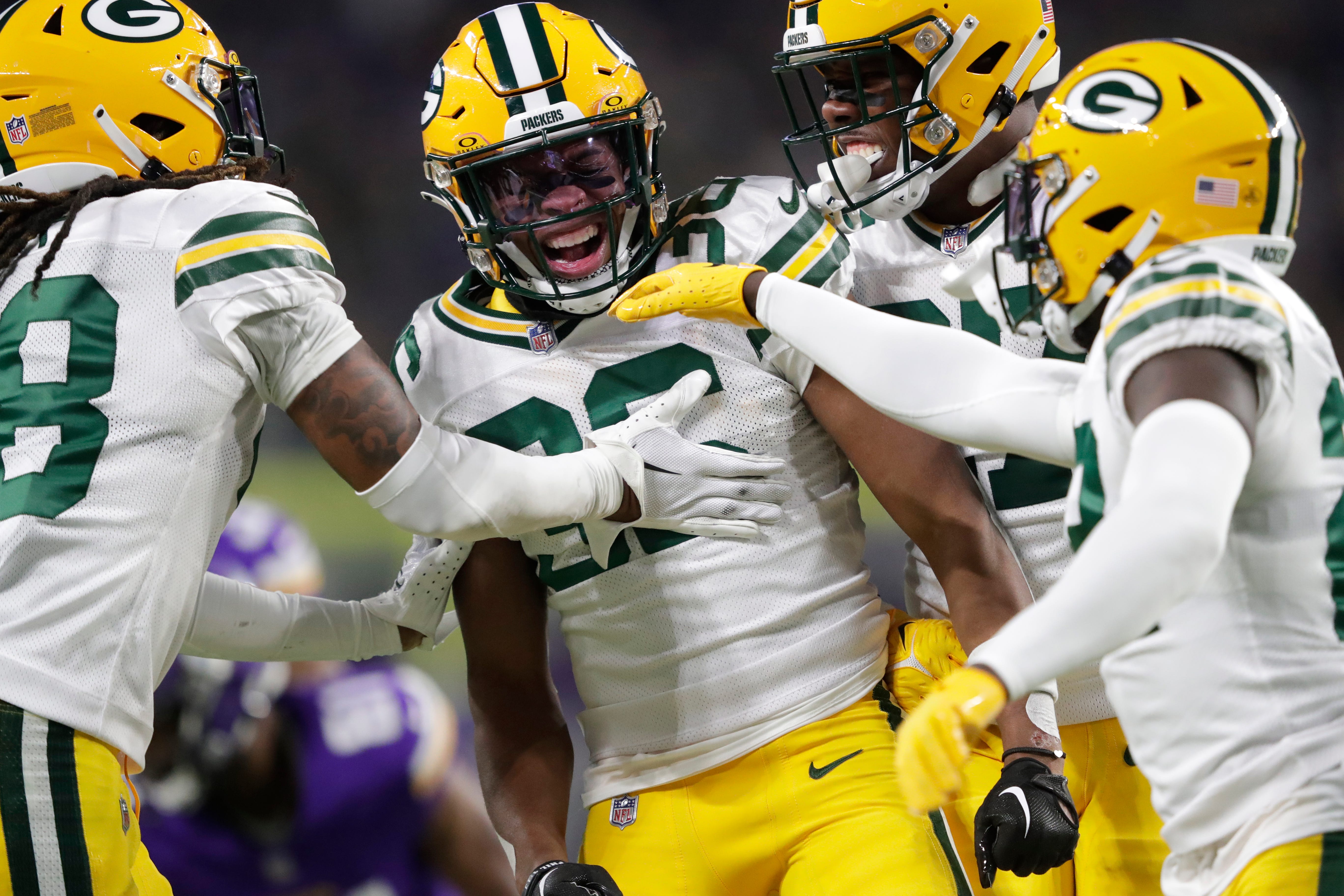 Green Bay Packers safety Anthony Johnson Jr. (36) is swarmed by teammates after making a special teams tackle against Minnesota Vikings running back Kene Nwangwu (26) during their football game Sunday, December 31, 2023, at U.S. Bank Stadium in Minneapolis, Minnesota.