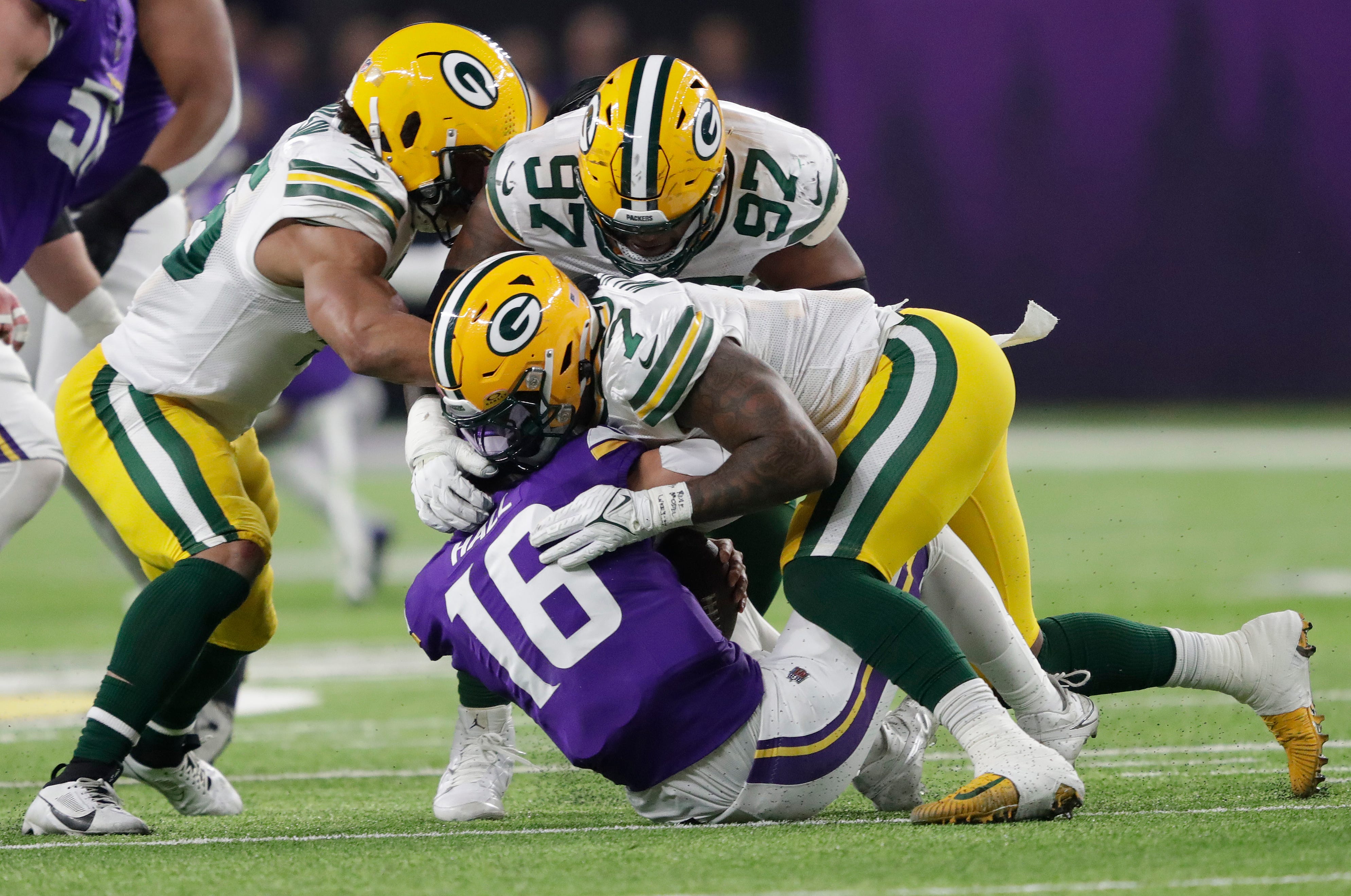 Green Bay Packers linebacker Quay Walker (7) sacks Minnesota Vikings quarterback Jaren Hall (16) during their football game Sunday, Dec. 31, 2023, at U.S. Bank Stadium in Minneapolis, Minnesota.