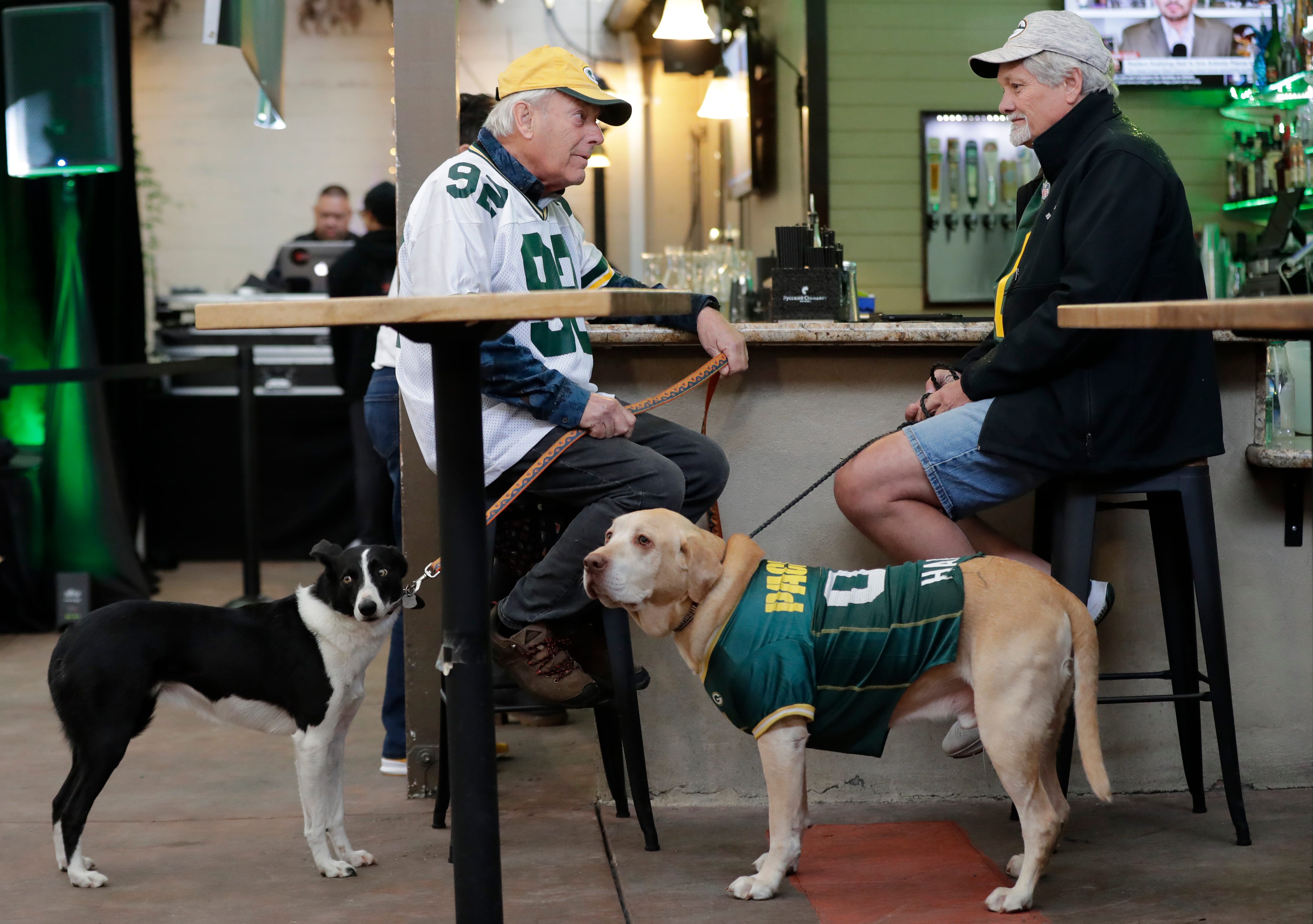 Green Bay Packers fans John Smit, left, of California and his dog Josie hangs out with Tony Smet and his dog Harley shortly before the start of the Packers Everywhere pep rally Friday, January 19, 2024, at The Patio in Palo Alto, California.