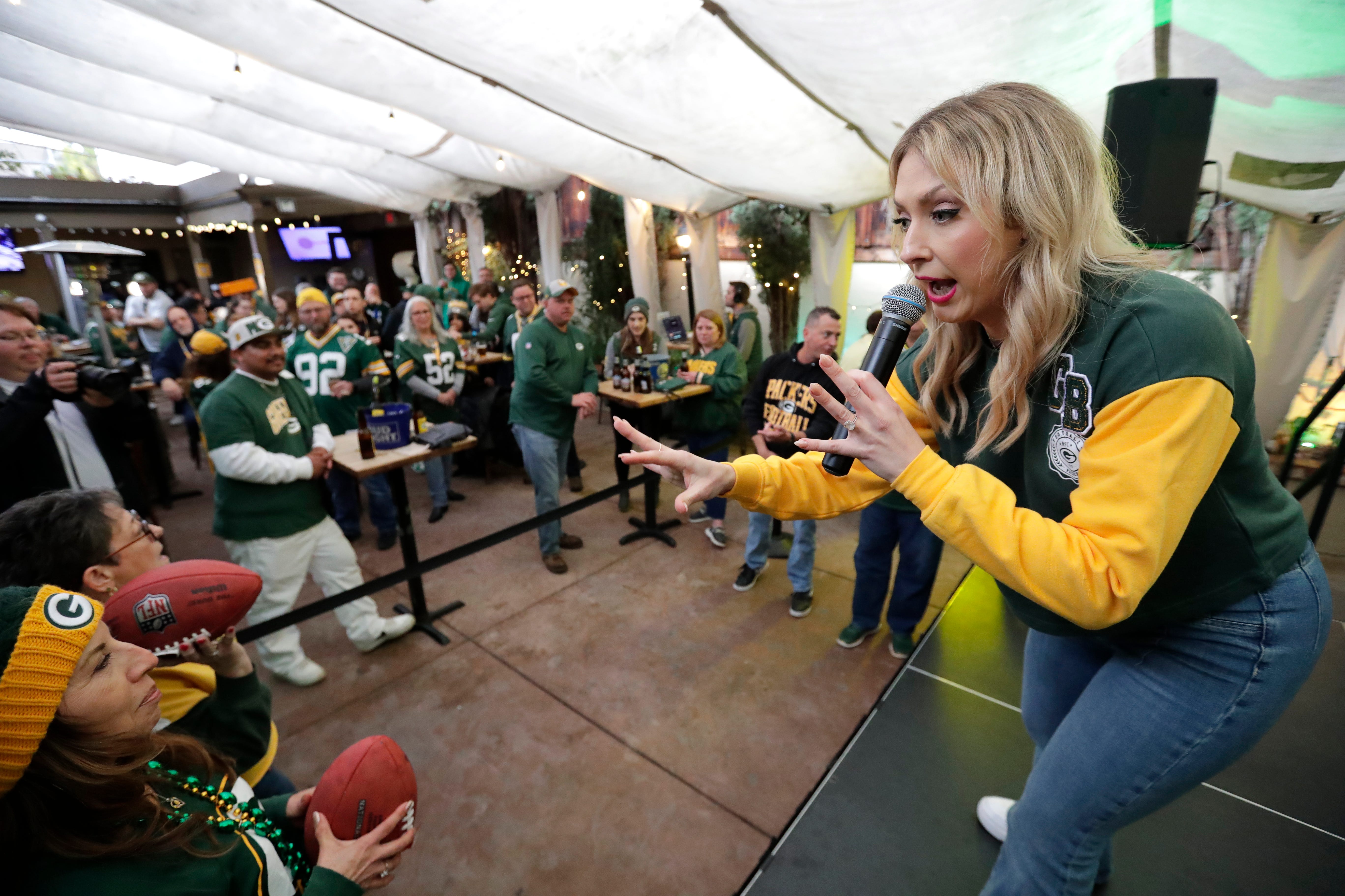 Packers Everywhere host Rebecca Zaccard teaches fans the rules of a game to win prizes during the Packers Everywhere pep rally Friday, January 19, 2024, at The Patio in Palo Alto, California.