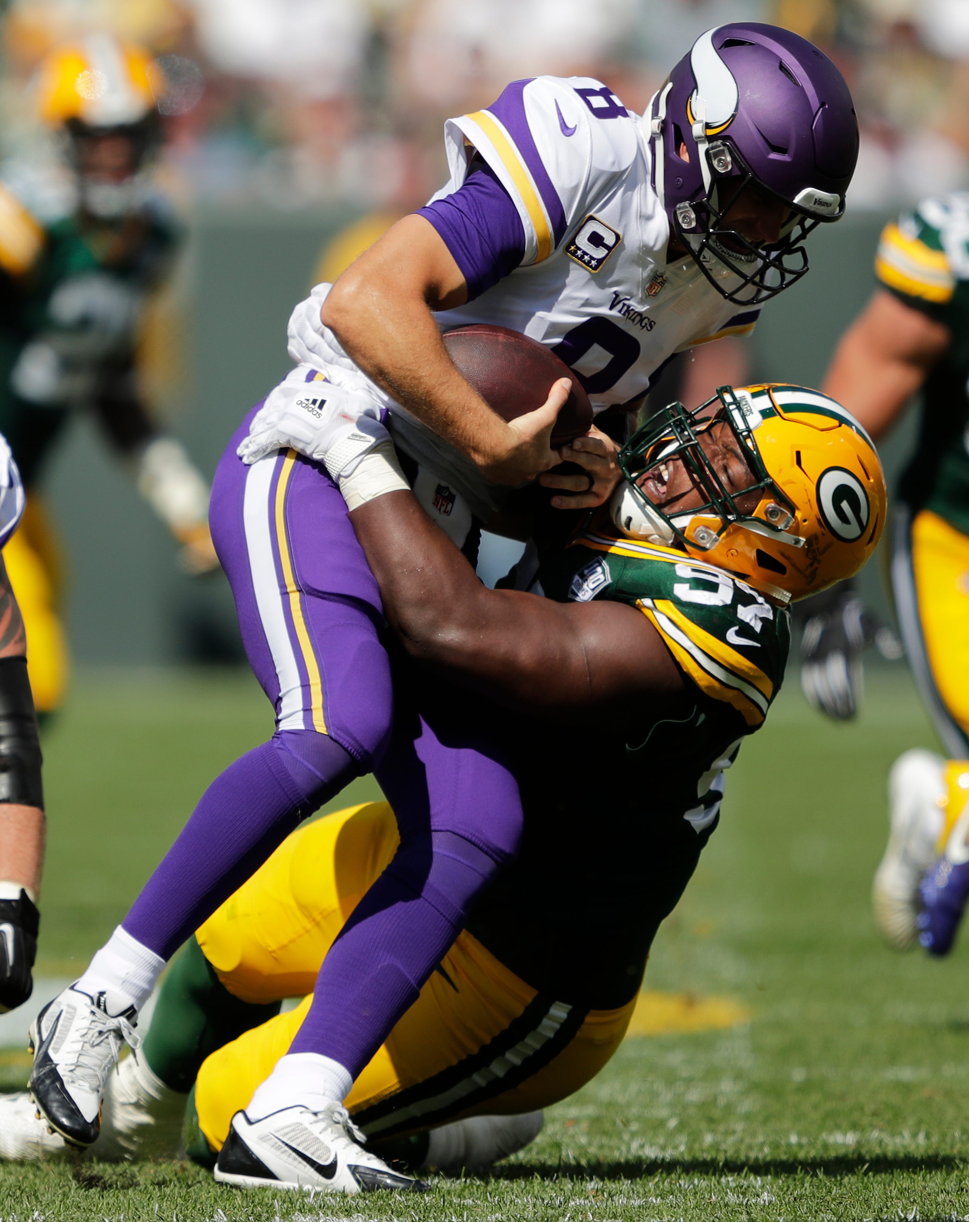 Green Bay Packers nose tackle Kenny Clark (97) sacks Minnesota Vikings quarterback Kirk Cousins (8) in the third quarter during their football game Sunday, Sept. 16, 2018, at Lambeau Field in Green Bay, Wis.