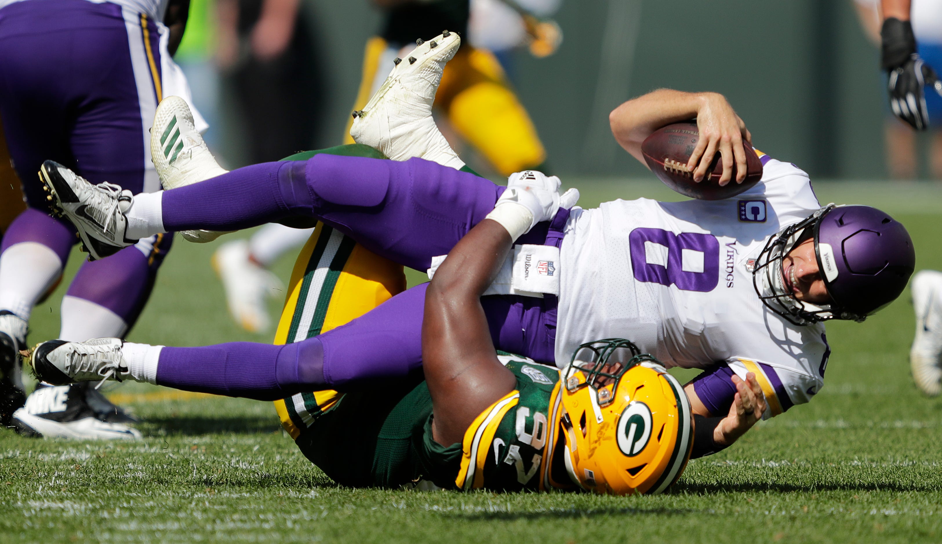Green Bay Packers nose tackle Kenny Clark (97) sacks Minnesota Vikings quarterback Kirk Cousins (8) in the third quarter during their football game Sunday, Sept. 16, 2018, at Lambeau Field in Green Bay, Wis.