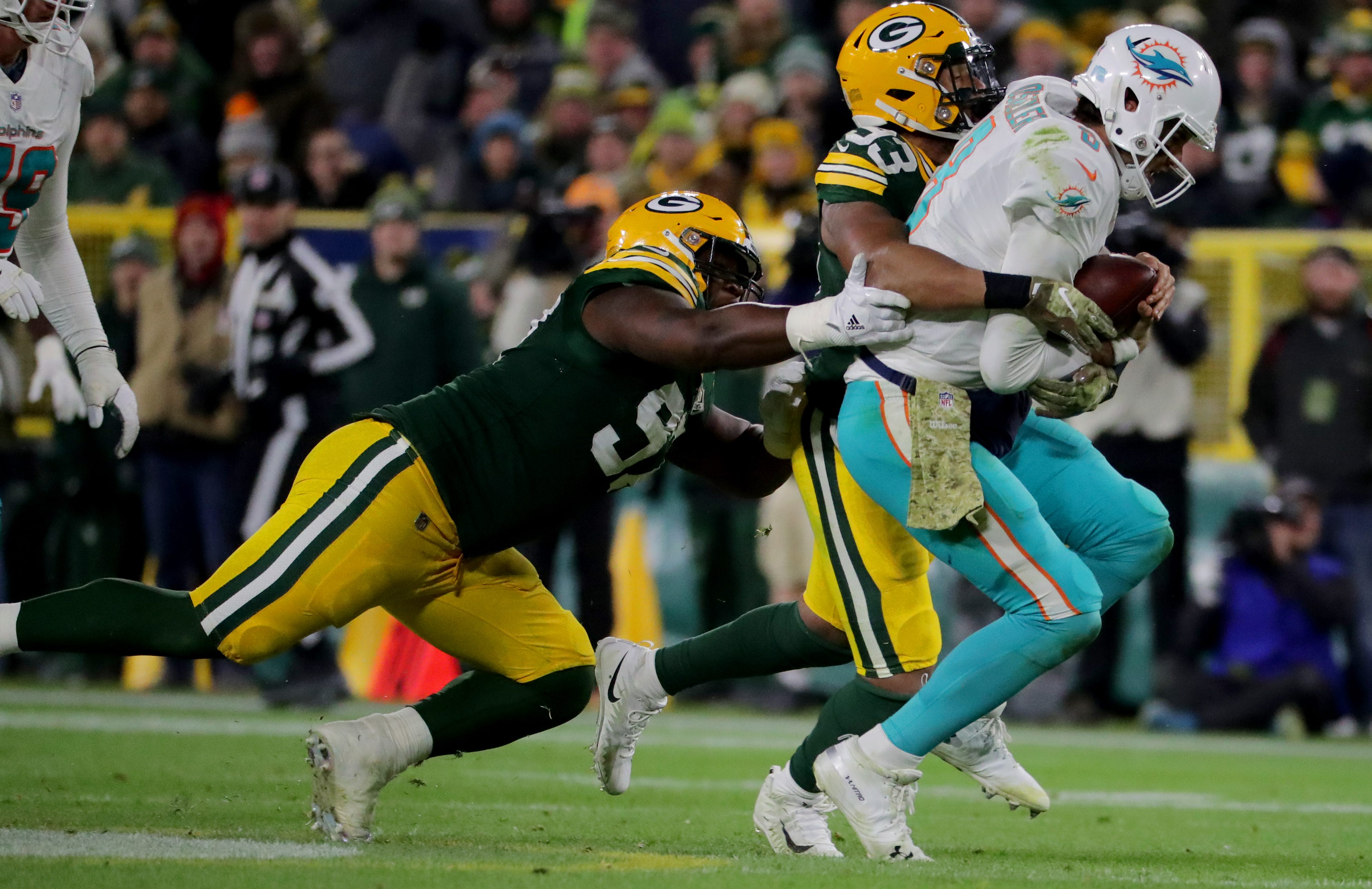 Green Bay Packers nose tackle Kenny Clark (97), left, and Green Bay Packers linebacker Reggie Gilbert (93) sack Miami Dolphins quarterback Brock Osweiler (8) during the 4th quarter of the Green Bay Packers 31-12 win against the Miami Dolphins at Lambeau Field in Green Bay, Wis. on Sunday, November 11, 2018. Mike De Sisti / USA TODAY NETWORK-Wis
