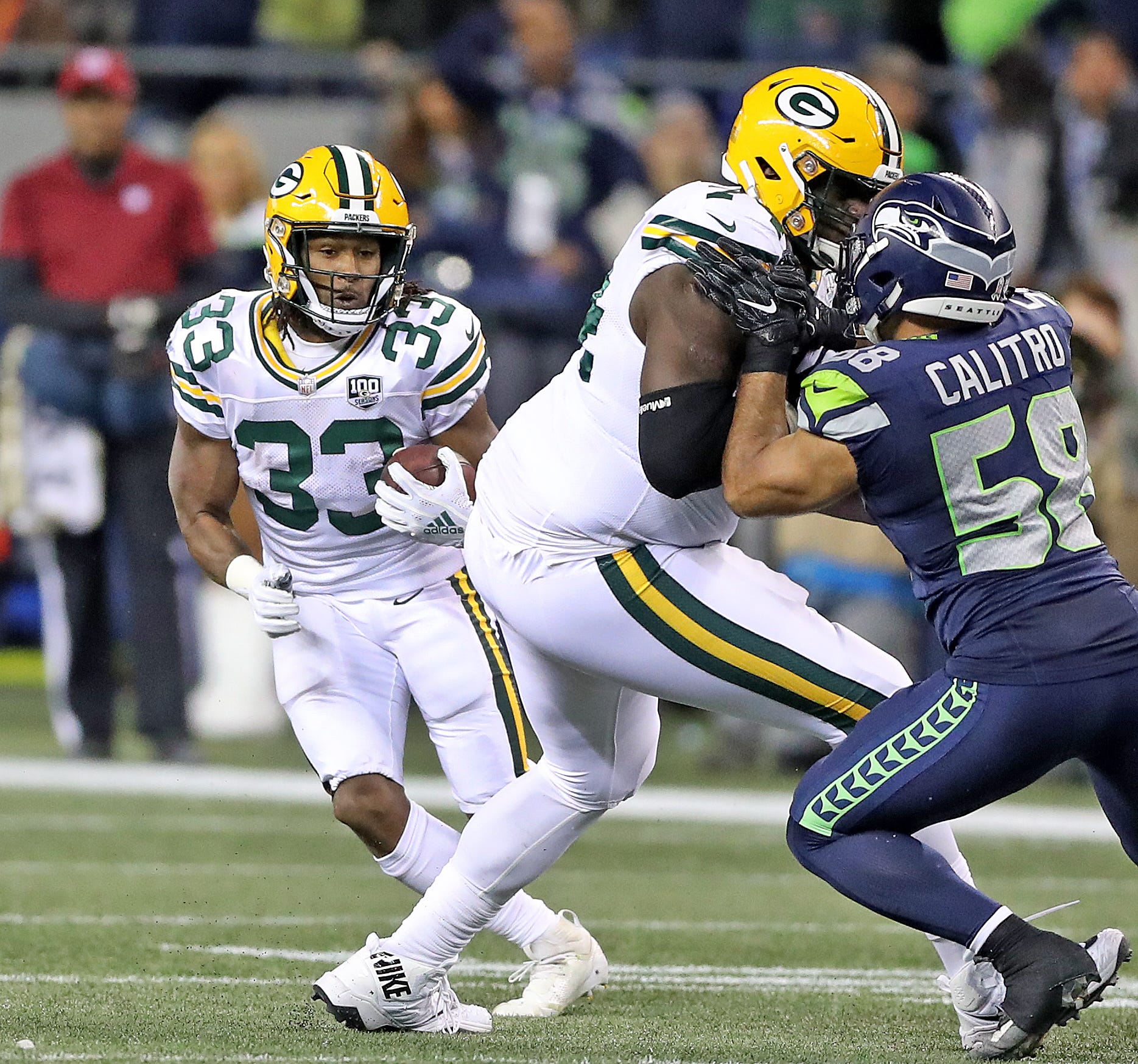 Green Bay Packers running back Aaron Jones (33) cuts behind the block of offensive guard Byron Bell (74) on outside linebacker Austin Calitro (58) on a screen pass against the Seattle Seahawks at CenturyLink Field Thursday, November 15, 2018 in Seattle, WA. Jim Matthews/USA TODAY NETWORK-Wis