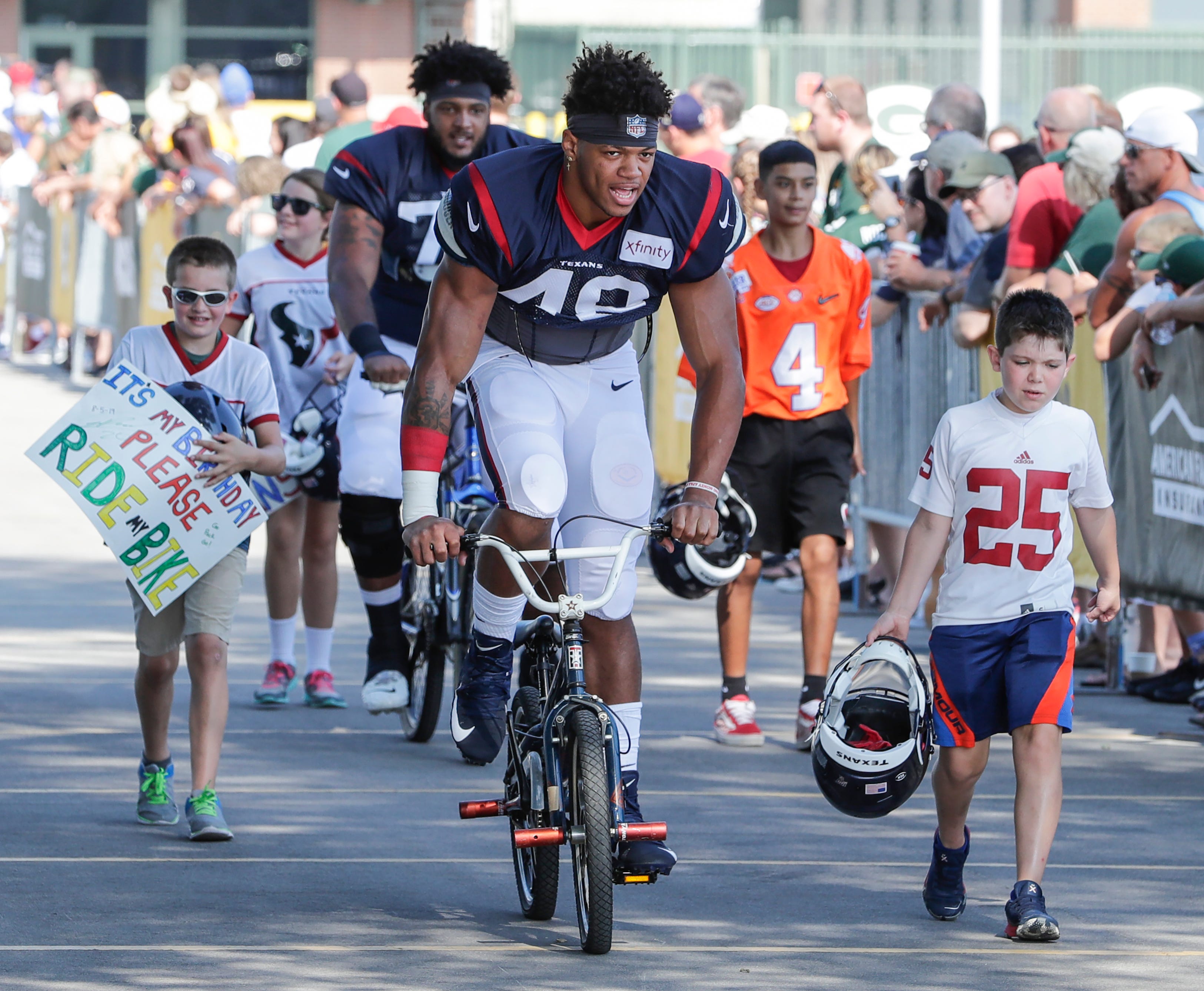 Texans outside linebacker Davin Bellamy (48) joins the Packers tradition of riding bikes to Don Hinckle Field for a joint training camp practice with the Green Bay Packers Monday, August 5, 2019, in Ashwaubenon, Wis.