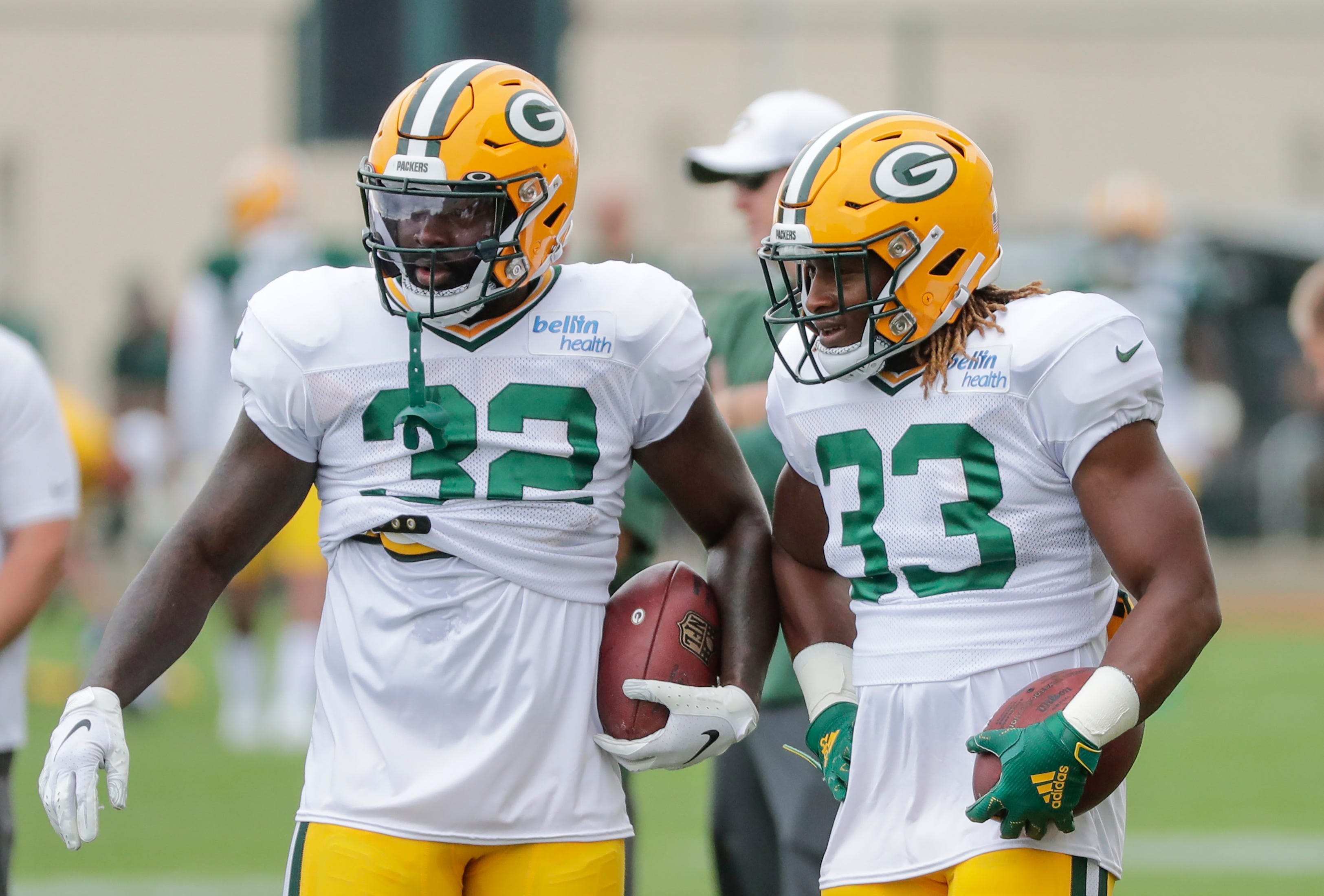 Green Bay Packers' Tra Carson (32) talks with Aaron Jones (33) during training camp practice Tuesday, August 13, 2019, at Ray Nitschke Field in Ashwaubenon, Wis.