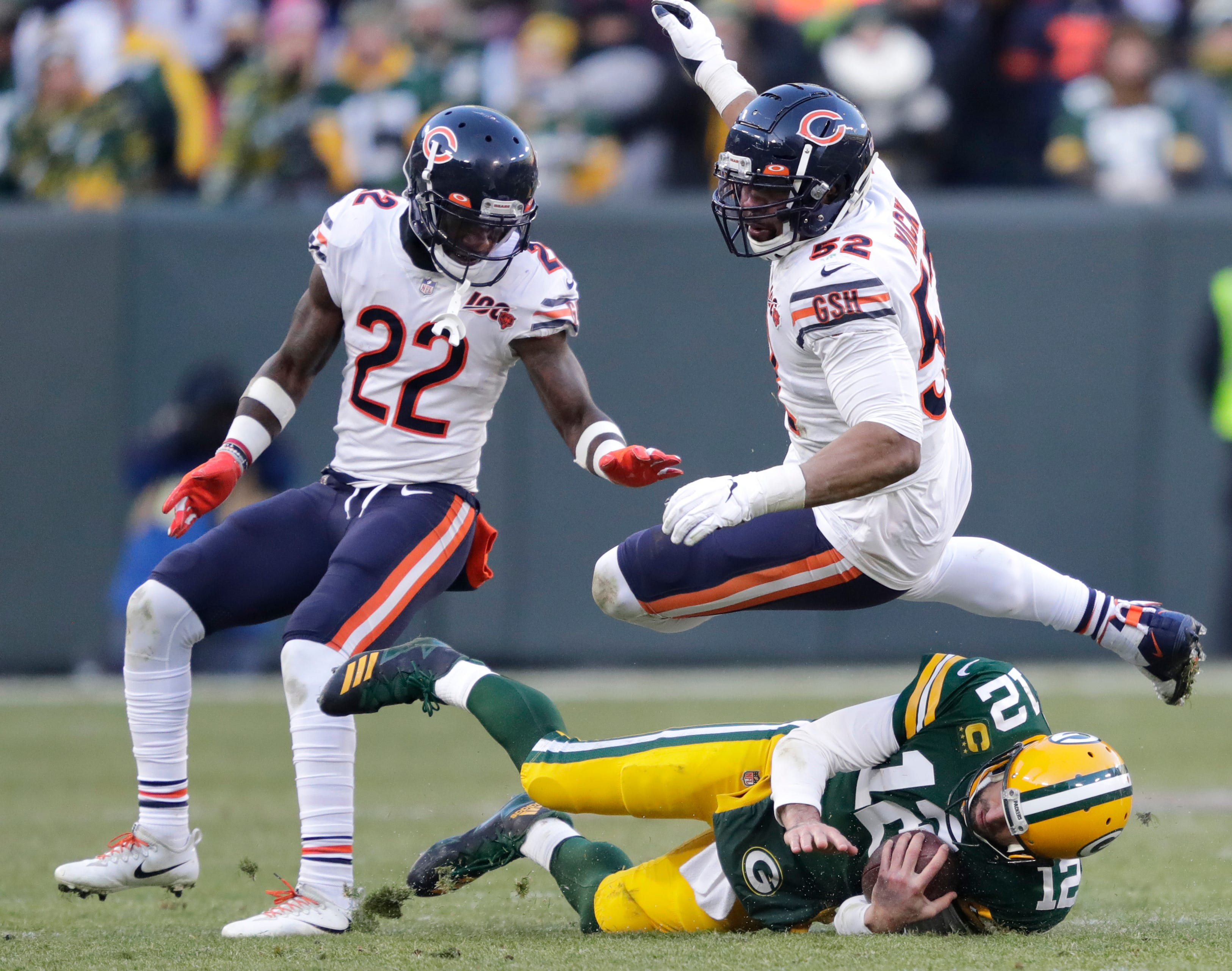 Green Bay Packers quarterback Aaron Rodgers (12) slides after a gain on third down against Chicago Bears defensive back Kevin Toliver (22) and Khalil Mack (52) late in the fourth quarter Sunday, December 15, 2019, at Lambeau Field in Green Bay, Wis. Green Bay punted on the next play.