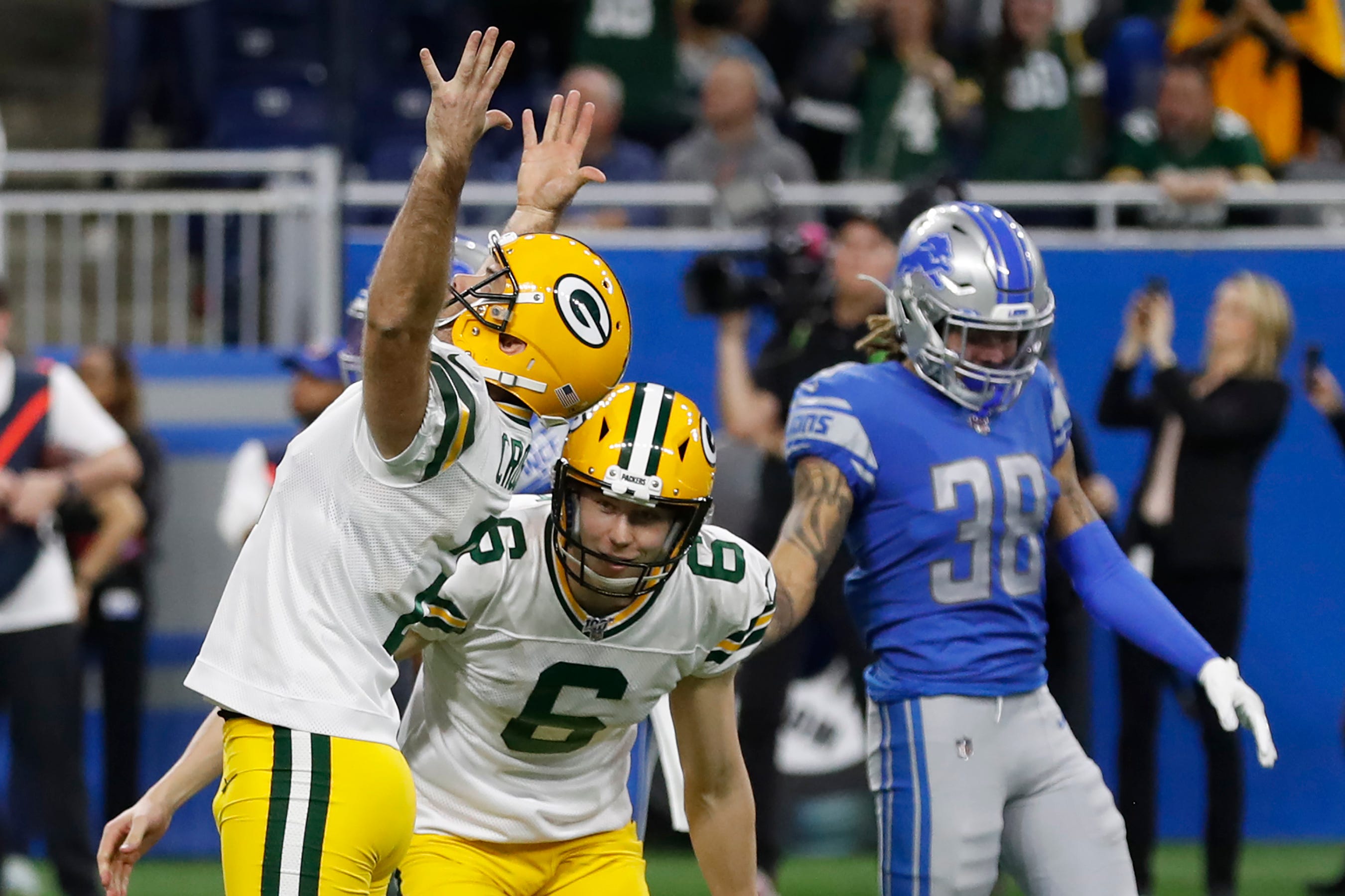 Green Bay Packers kicker Mason Crosby raises his arms after making the winning field goal during the second half of an NFL football game against the Detroit Lions, Sunday, Dec. 29, 2019, in Detroit. Lions defensive back Mike Ford (38) looks on.