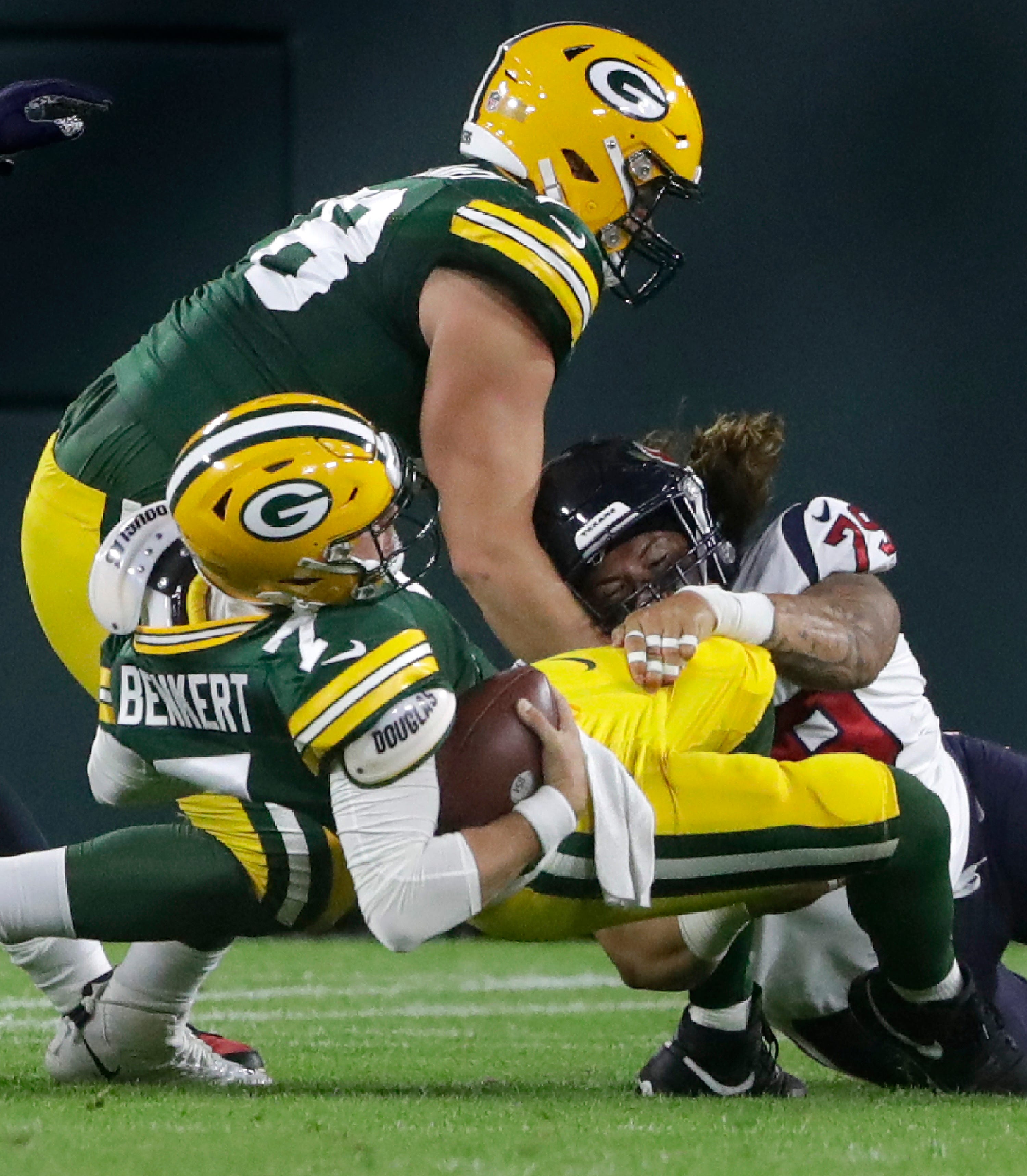 Green Bay Packers quarterback Kurt Benkert (7) is sacked by Houston Texans defensive tackle Roy Lopez (79) during their preseason football game at Lambeau Field in Green Bay.