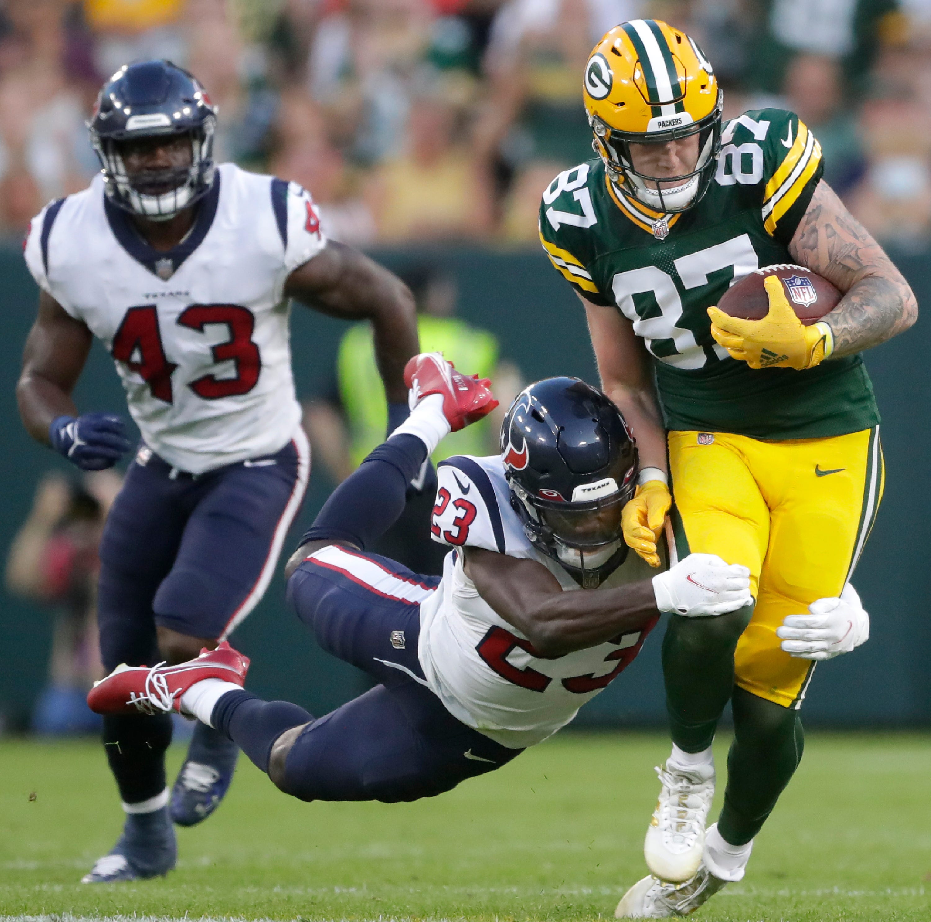 Green Bay Packers tight end Jace Sternberger (87) catches a pass and is tackled by Houston Texans safety Eric Murray (23) during their preseason football game at Lambeau Field in Green Bay.