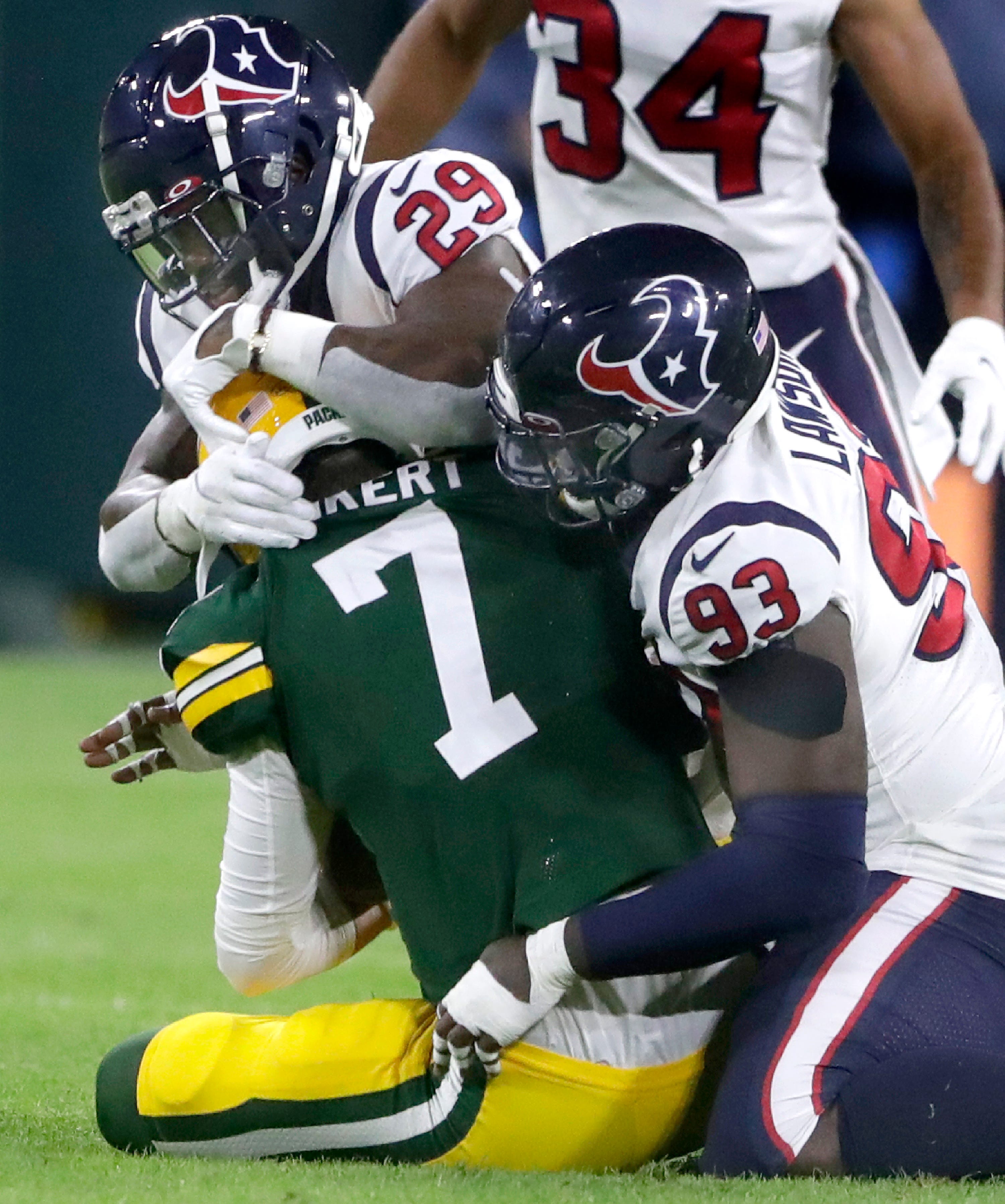 Green Bay Packers quarterback Kurt Benkert (7) is sacked by Houston Texans safety Terrence Brooks and defensive end Shaq Lawson during their preseason football game at Lambeau Field in Green Bay.