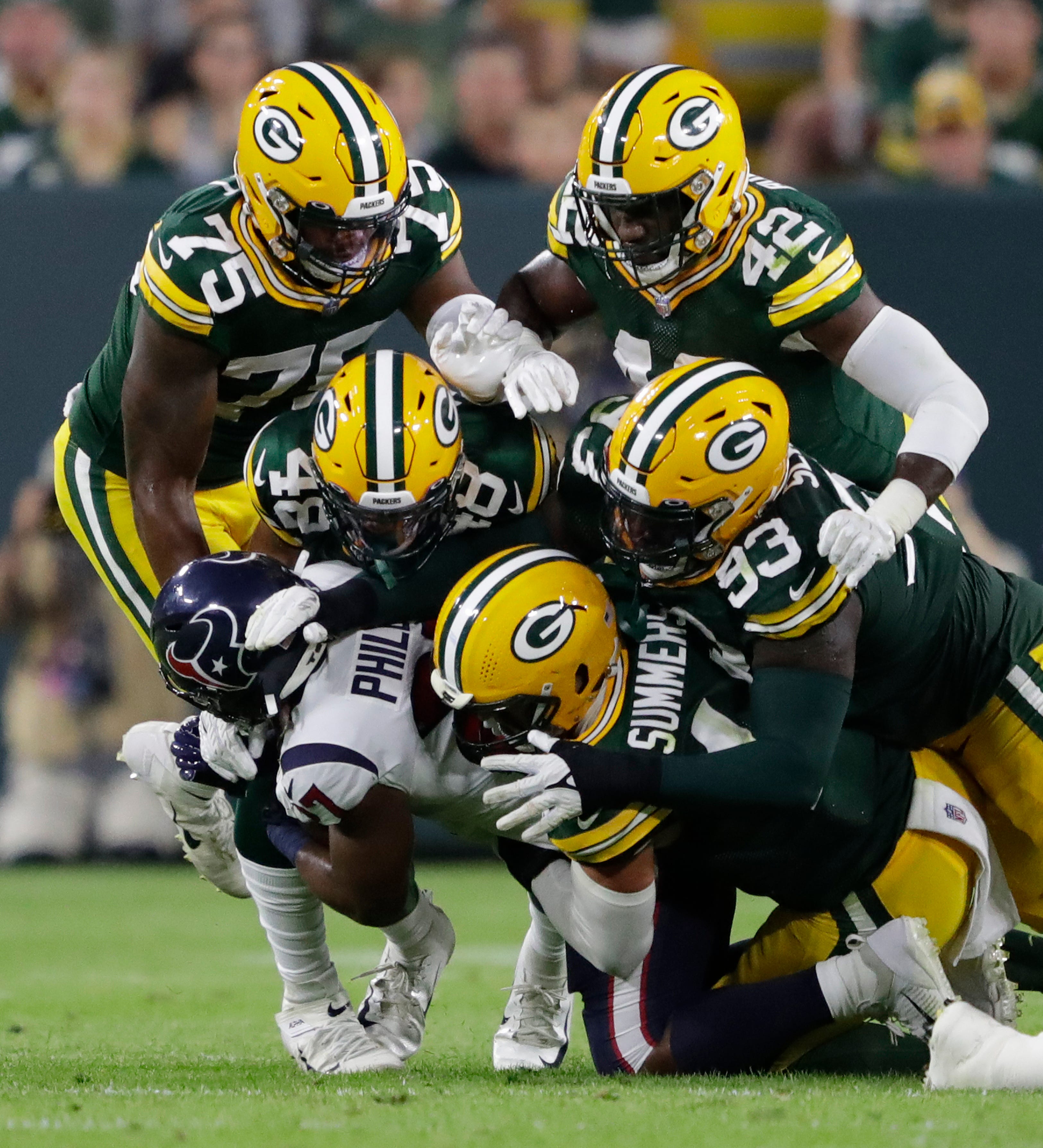 Houston Texans running back Scottie Phillips (27) is stopped by the Green Bay Packers defense during a preseason game on Saturday, Aug. 14, 2021, at Lambeau Field in Green Bay.