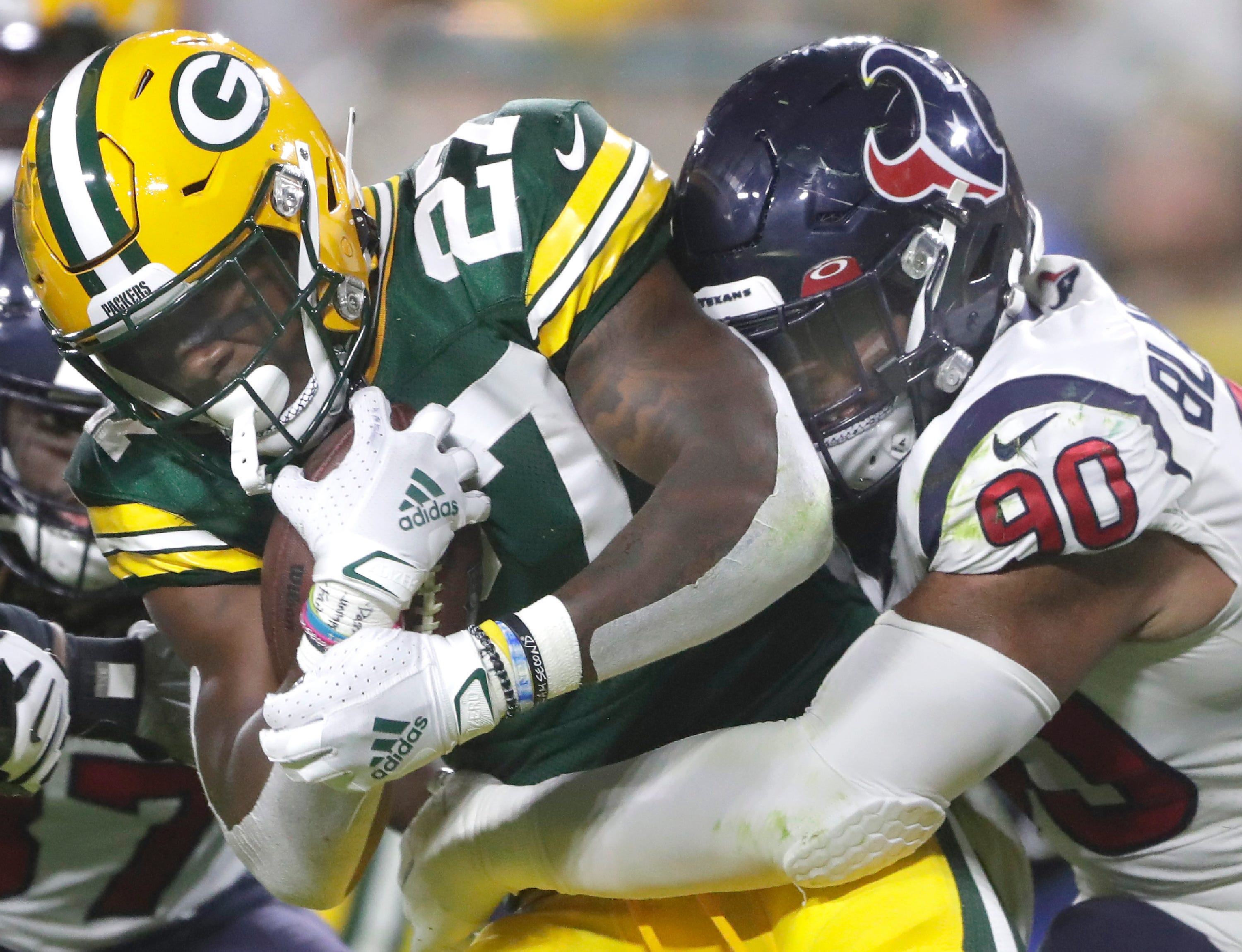 Green Bay Packers running back Patrick Taylor (27) is tackled by Houston Texans defensive tackle Ross Blacklock (90) during their preseason football game  at Lambeau Field in Green Bay.