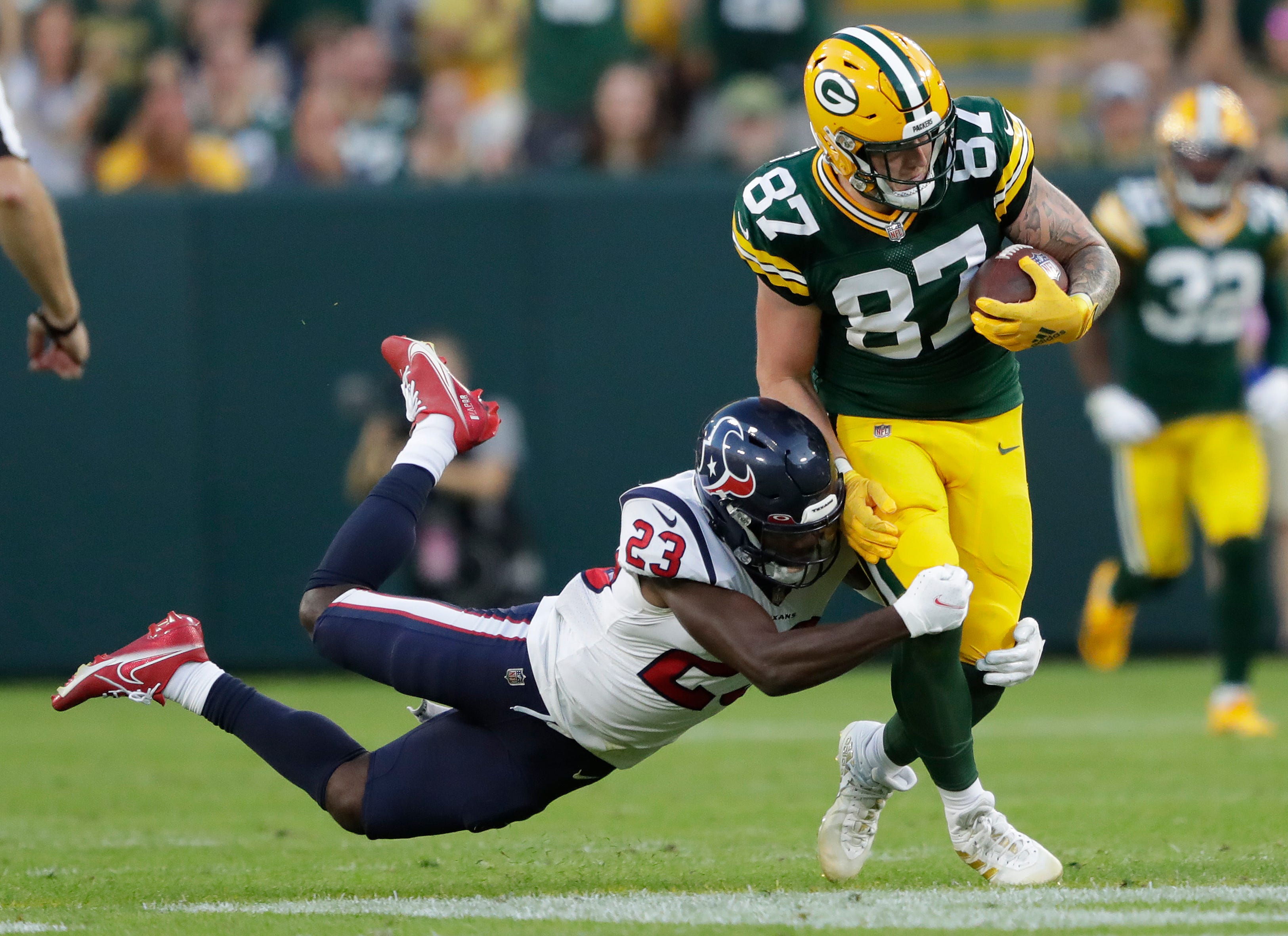 Green Bay Packers tight end Jace Sternberger (87) runs for yardage on a first down reception against Houston Texans safety Eric Murray (23) during a preseason game on Saturday, Aug. 14, 2021, at Lambeau Field in Green Bay.