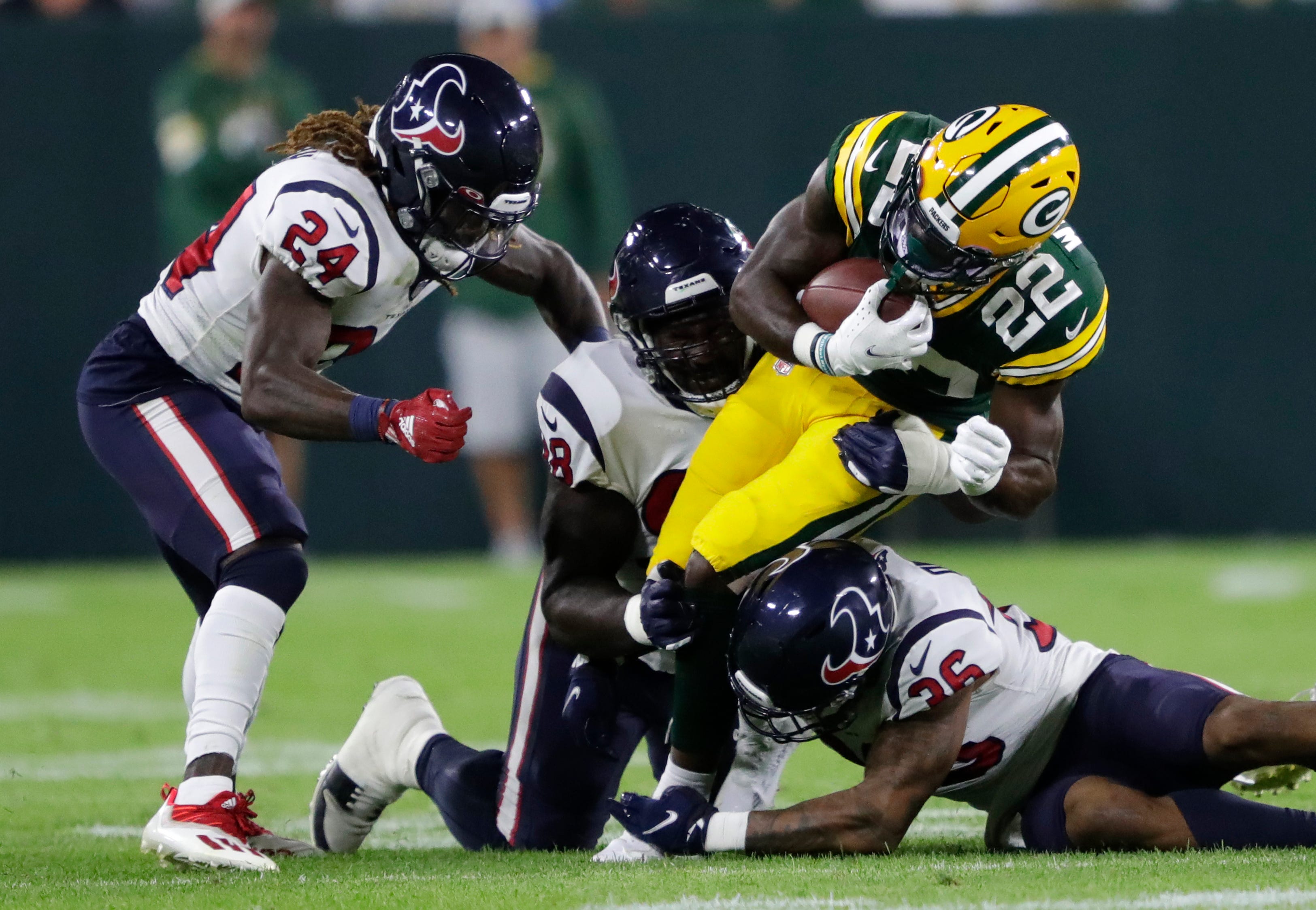 Green Bay Packers running back Dexter Williams (22) runs against Houston Texans cornerback Tremon Smith (24), defensive tackle Auzoyah Alufohai (98) and safety.Jonathan Owens (36) during their football game at Lambeau Field in Green Bay,