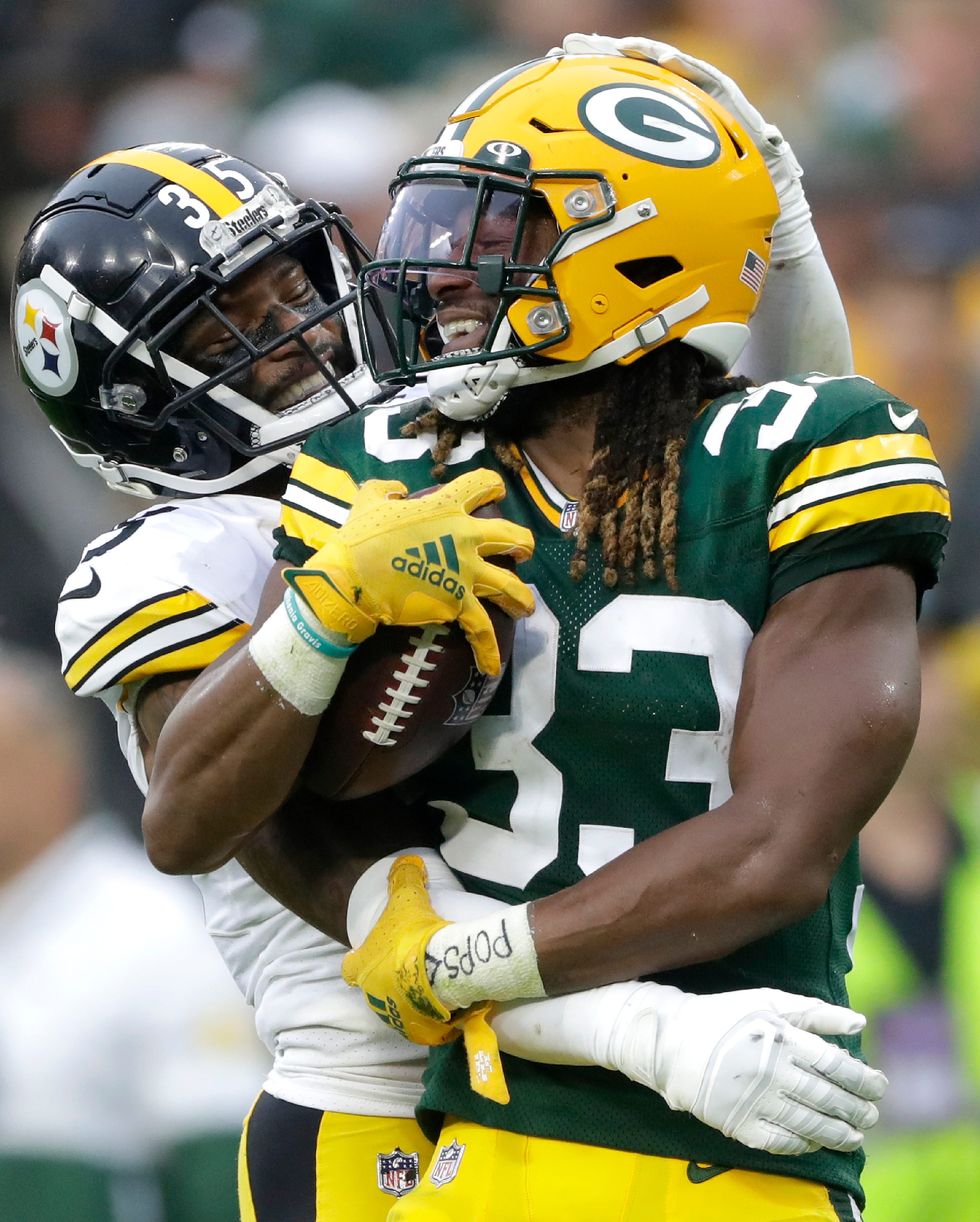 Green Bay Packers running back Aaron Jones (33) and Pittsburgh Steelers cornerback Arthur Maulet (35) are helmet-to-helmet during a play on Sunday, Oct.  3, 2021, at Lambeau Field in Green Bay.