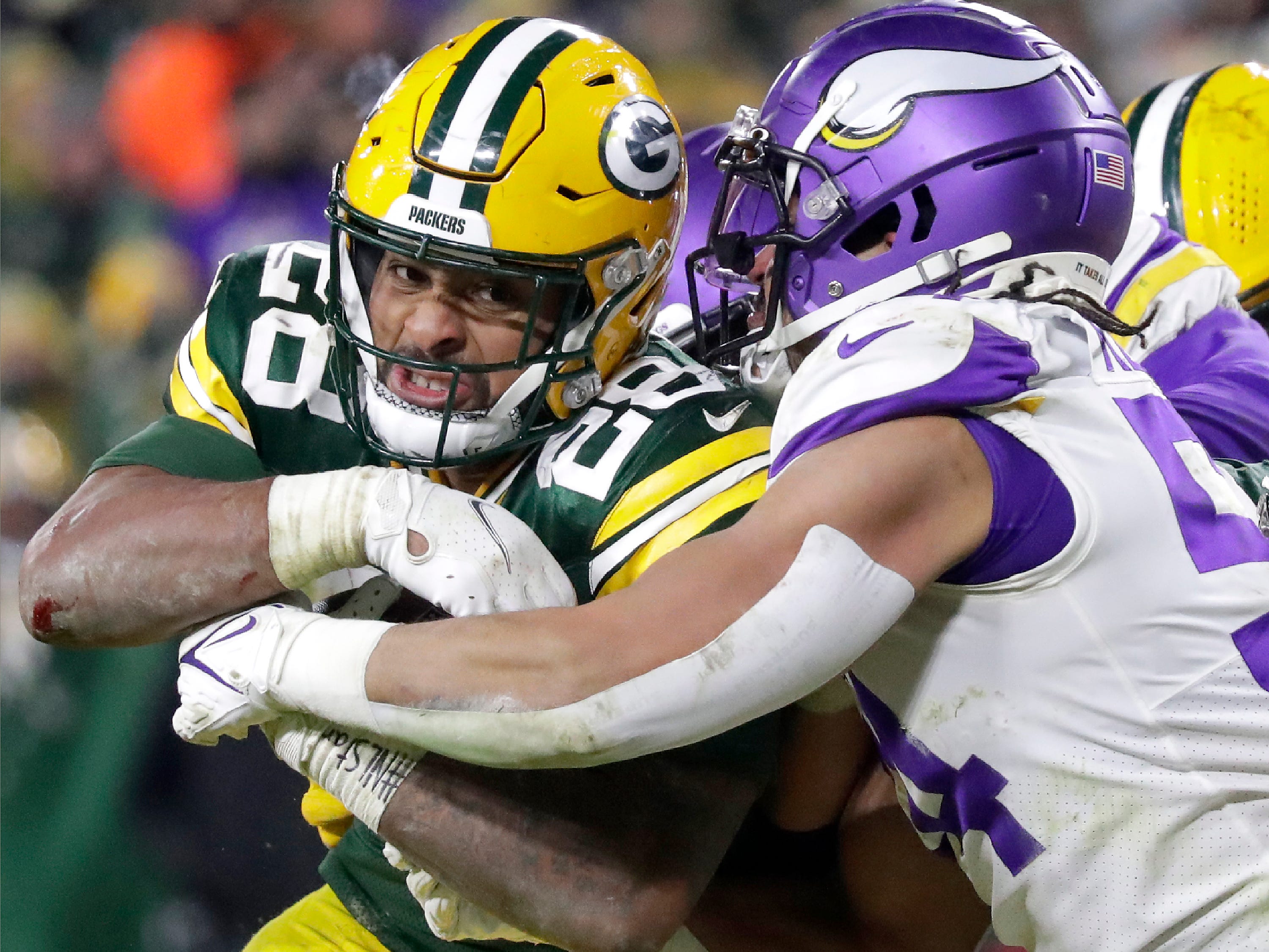 Green Bay Packers running back AJ Dillon (28) breaks the tackle attempt by Minnesota Vikings middle linebacker Eric Kendricks (54) on a fourth quarter touchdown run on Sunday, Jan. 2, 2022, at Lambeau Field in Green Bay.
