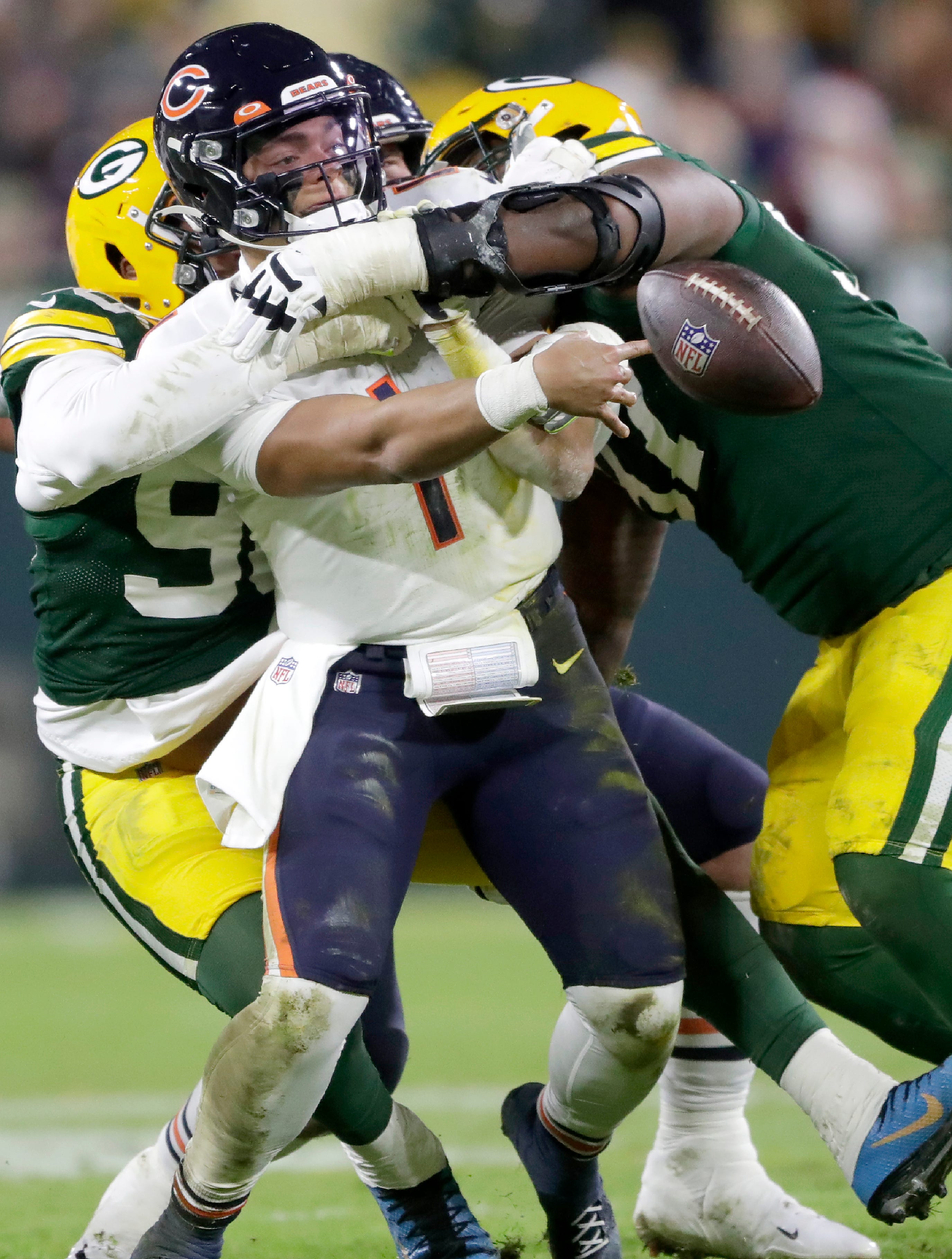 Chicago Bears quarterback Justin Fields (1) is sacked by Green Bay Packers defensive end Kingsley Keke (96) and nose tackle Kenny Clark (97) on Sunday, Dec. 12, 2021, at Lambeau Field in Green Bay, Wis.