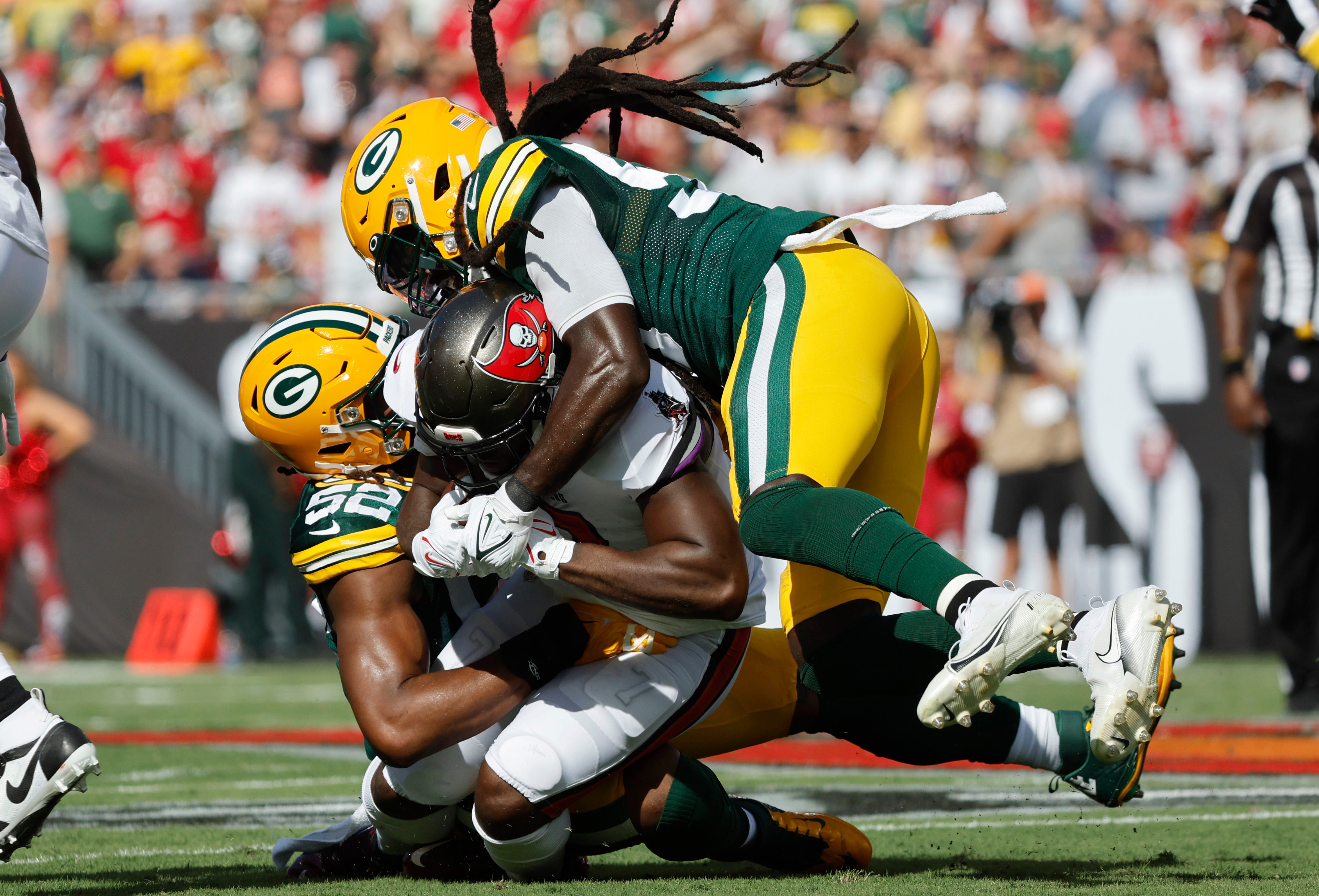 Tampa Bay Buccaneers running back Leonard Fournette (7) is brought down by Green Bay Packers linebacker De'Vondre Campbell (59) and linebacker Rashan Gary (52) during the first quarter on Sept. 25, 2022, at Raymond James Stadium in Tampa, Florida.